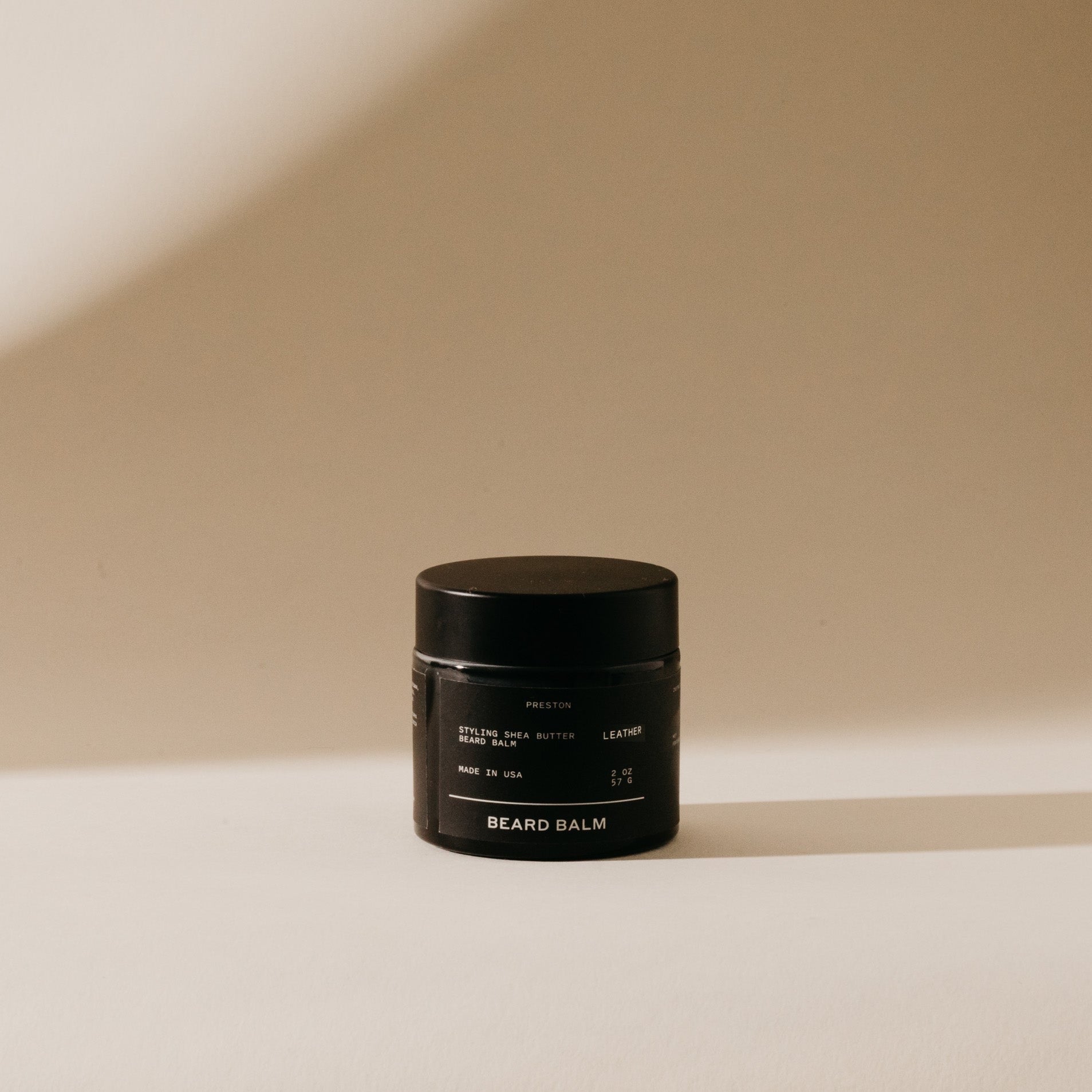 Beard balm jar, black container with gold label and screw-top lid