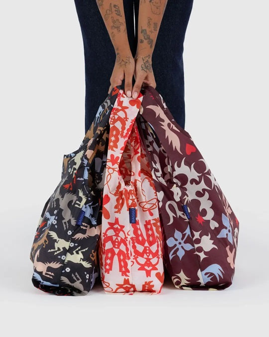 Three drawstring pouches in dark animal, red-and-white, and burgundy floral prints