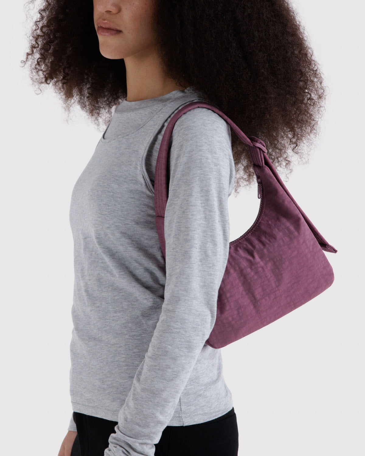 Mini nylon shoulder bag in plum worn crossbody with short adjustable strap