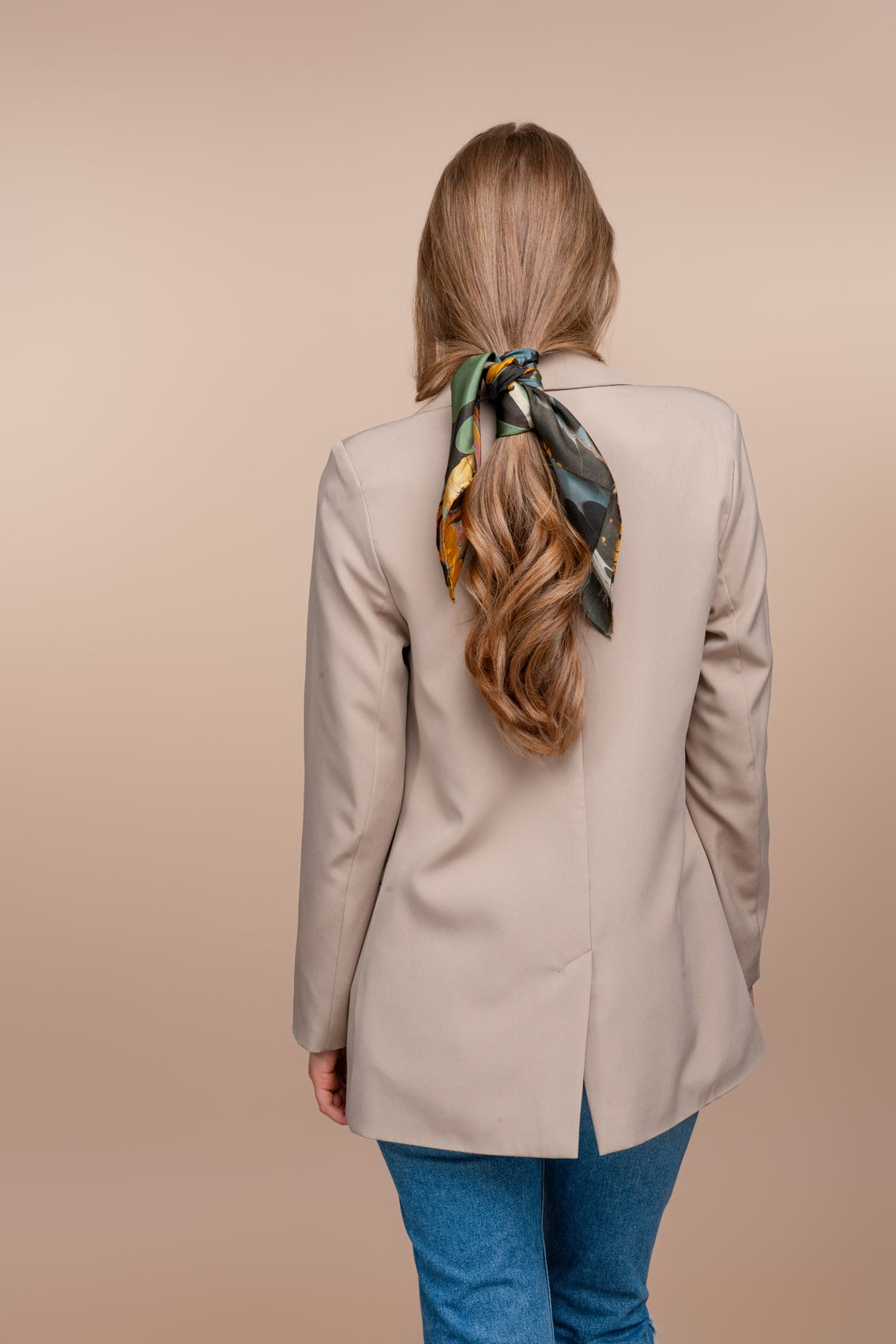 Abstract multicolor bandana tied in back of hair, green and orange ovals on dark