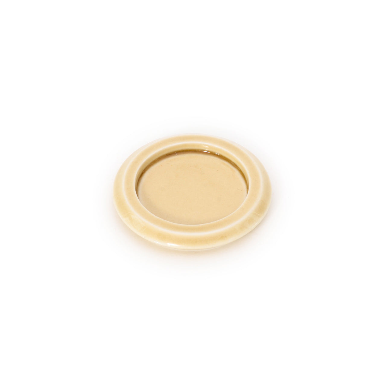 Cream-yellow ceramic incense tray with smooth round rim and centered dish