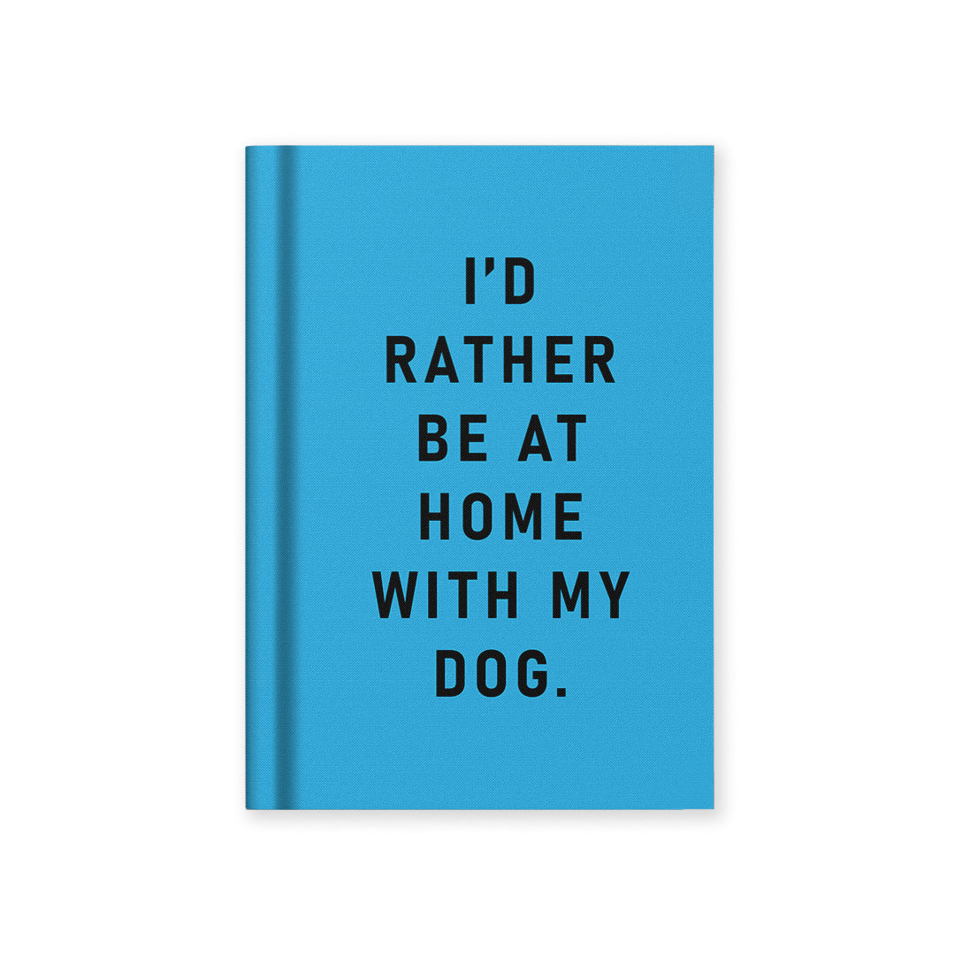 Blue hardback fabric notebook with black "I'd rather be at home with my dog" text