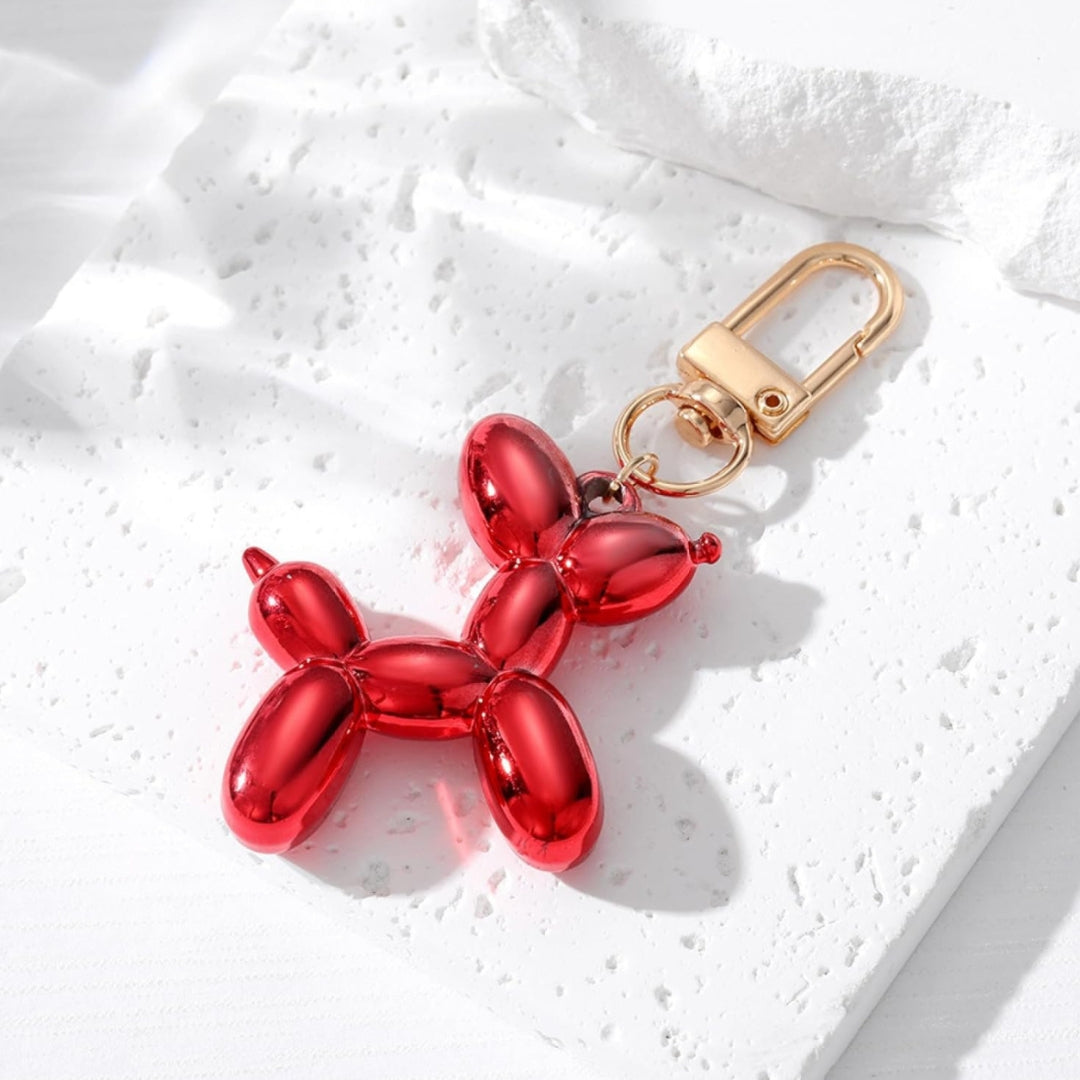 Red metallic balloon dog keychain with gold clasp and split-ring attachment