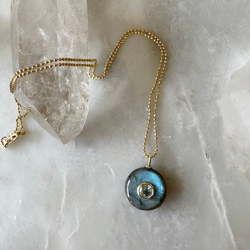 Gold vermeil chain necklace with round blue labradorite pendant and clear blue stone center.