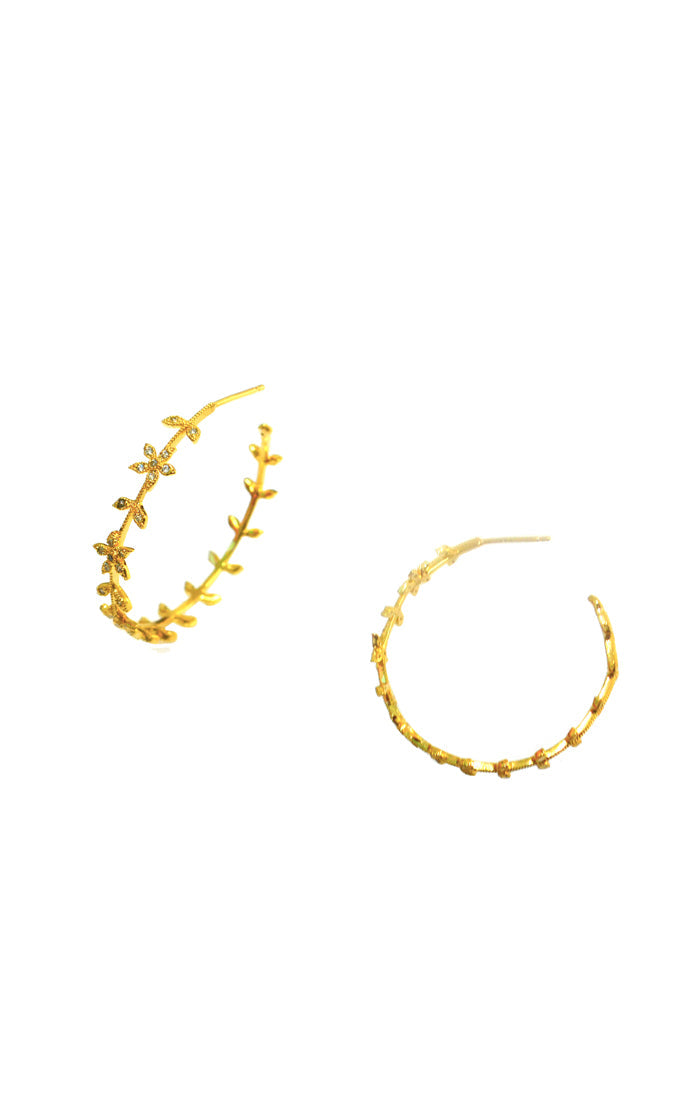 Gold-tone hoop earrings with small flower and leaf charms along the hoop