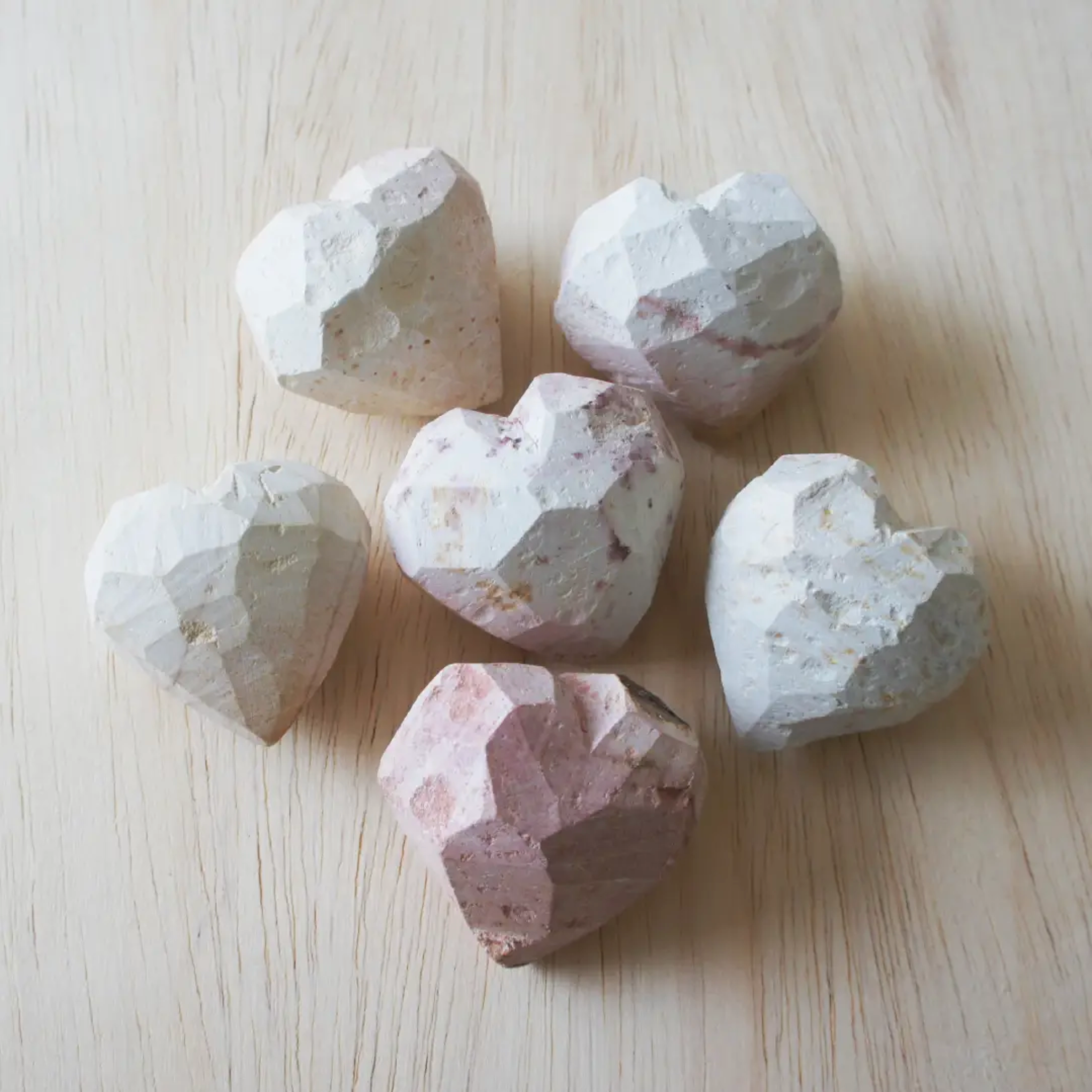 Set of carved soapstone hearts in white with pink and tan speckles