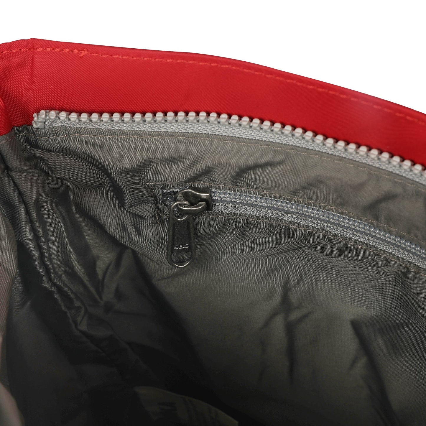 Red nylon crossbody interior with zippered pocket and gray lining