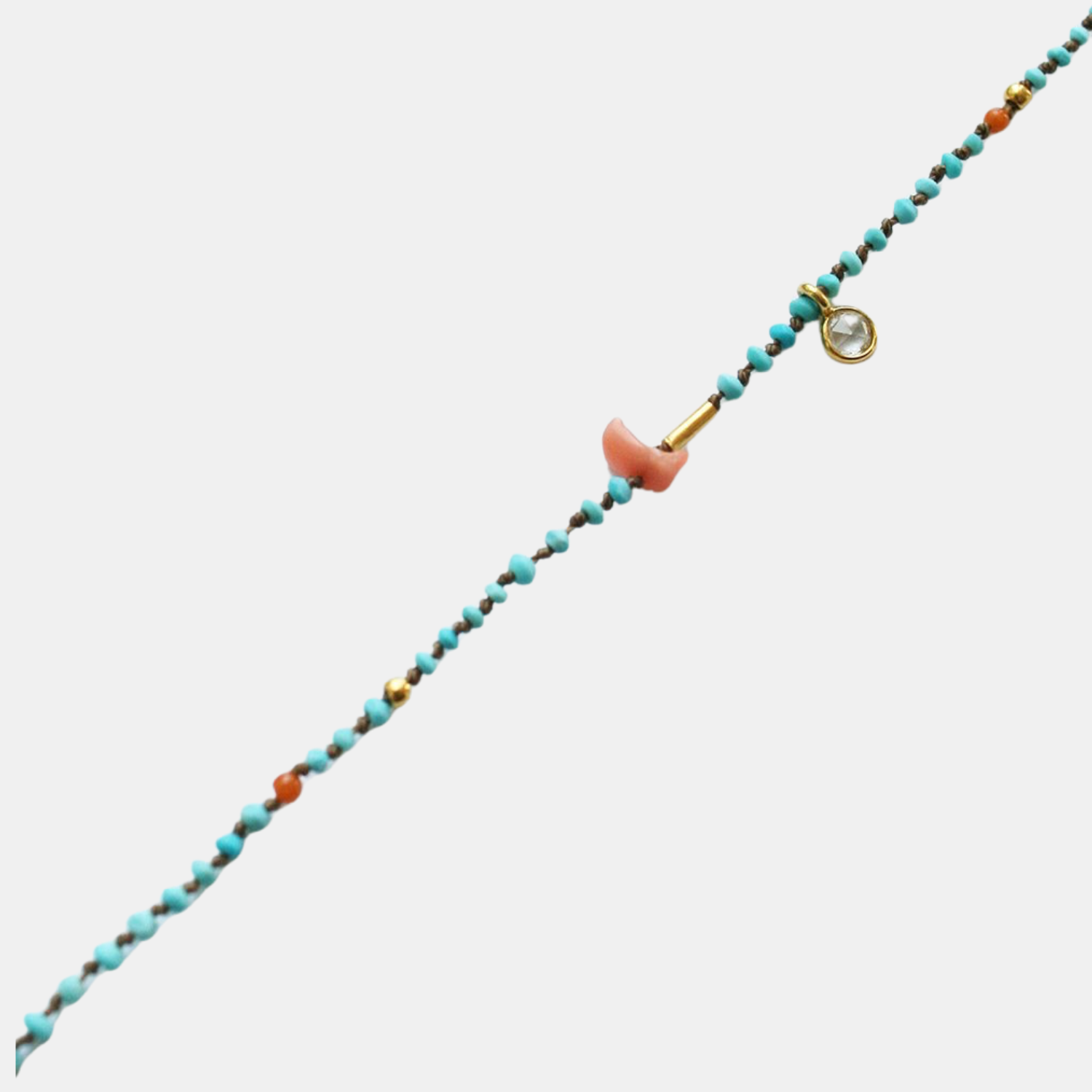 Turquoise beaded bracelet with orange end caps, gold bar, and round ring clasp