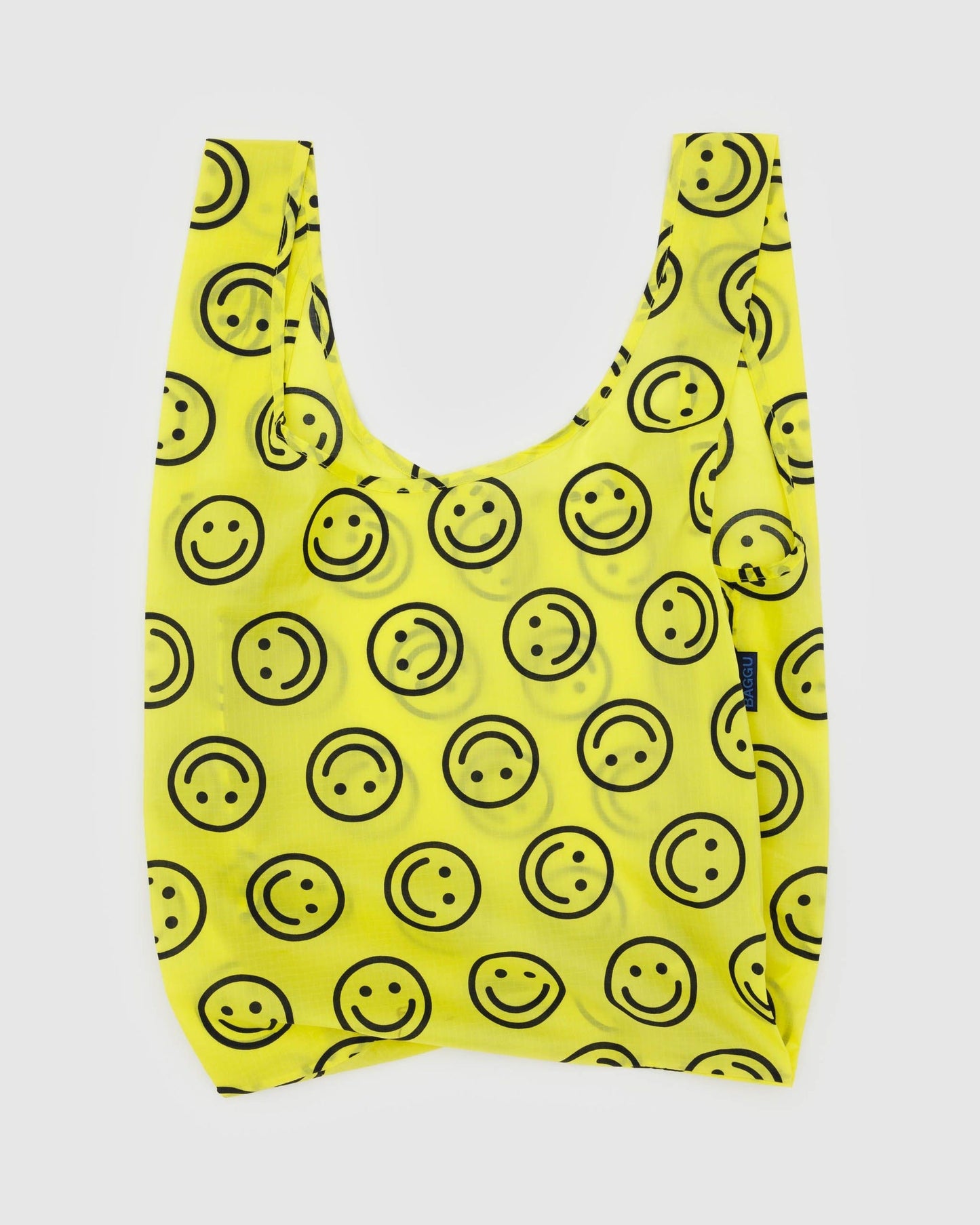 Reusable tote bag in bright yellow with smiley-face print and short U-shaped handles.