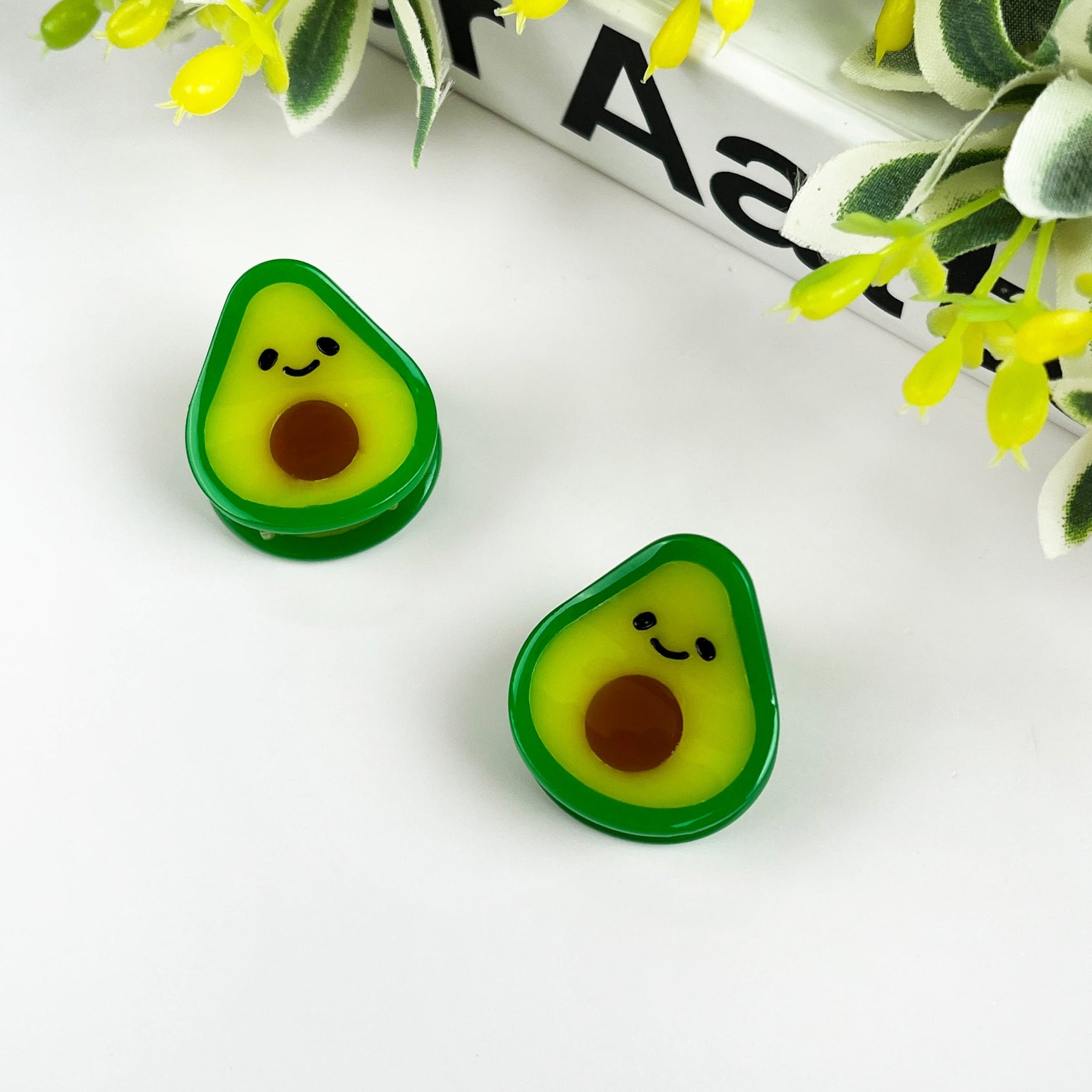 Avocado-shaped mini hair clips, green-yellow faces with brown seed detail (2-pack)