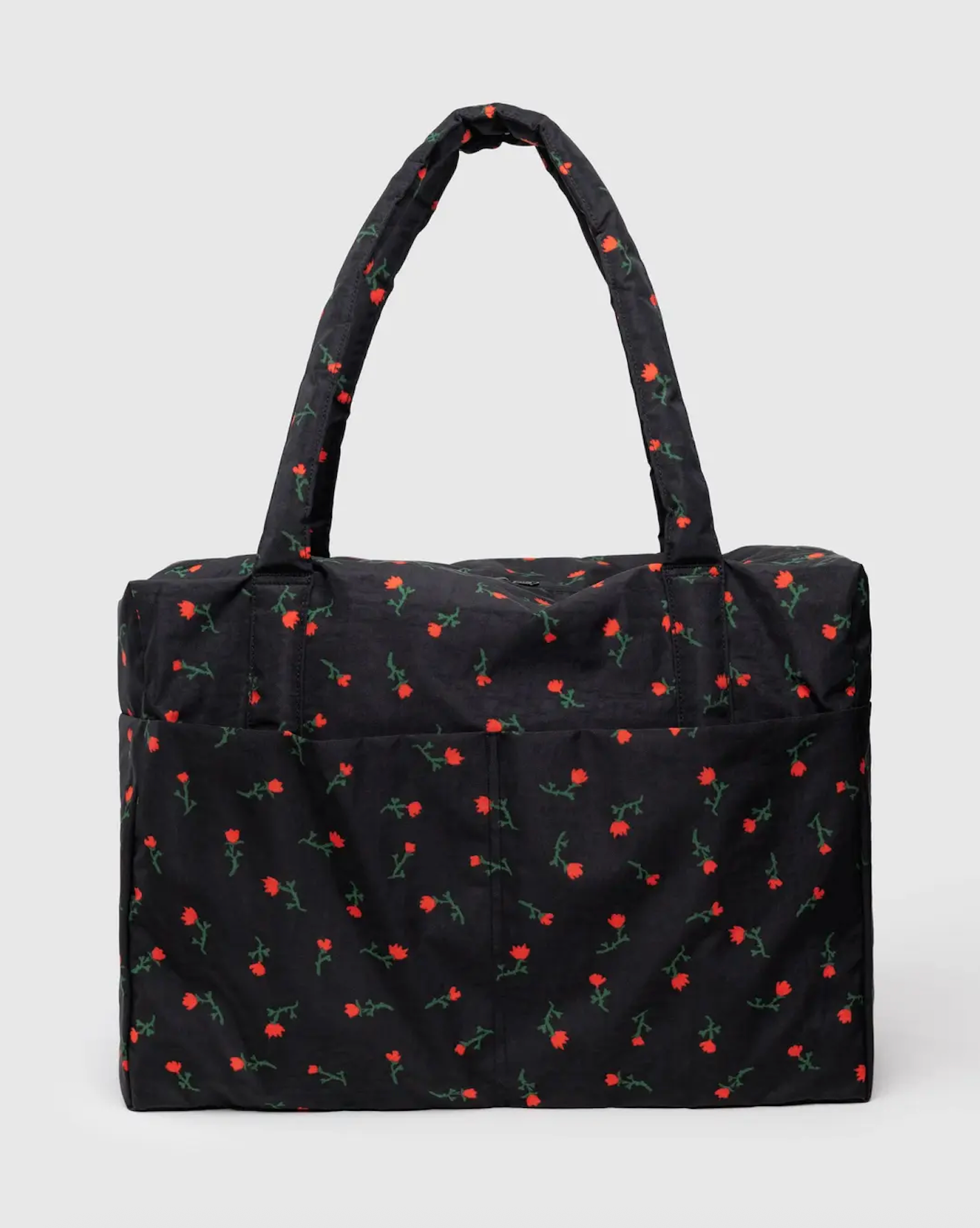 Carry-on travel bag with black base and small red cherry print, short top handles.