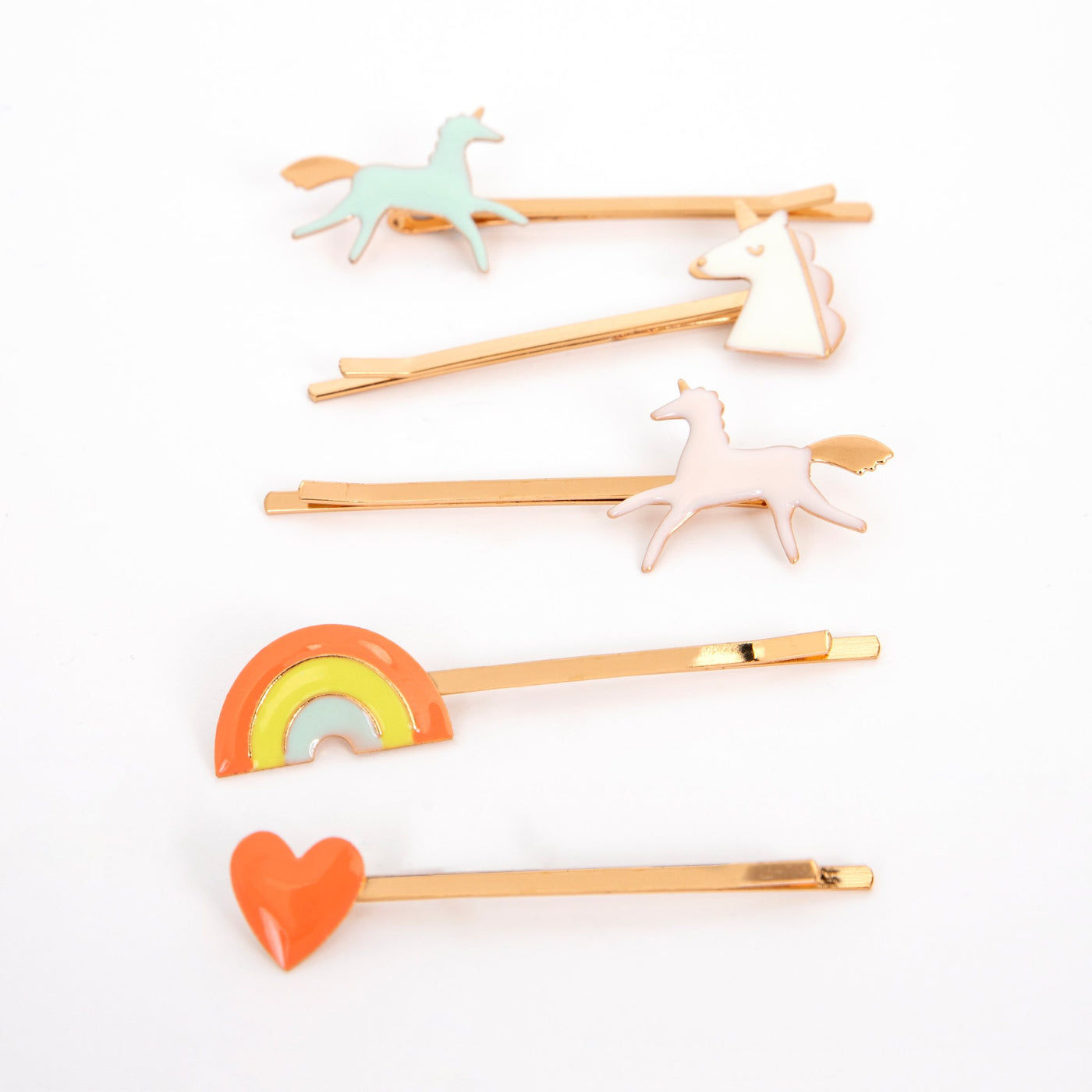 Enamel unicorn hair clips with pale unicorns, rainbow, and heart motifs on gold bars