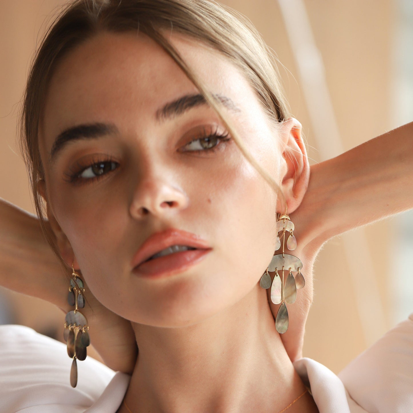 Mother-of-pearl chandelier earrings with gold hooks and layered teardrop drops, dark tones