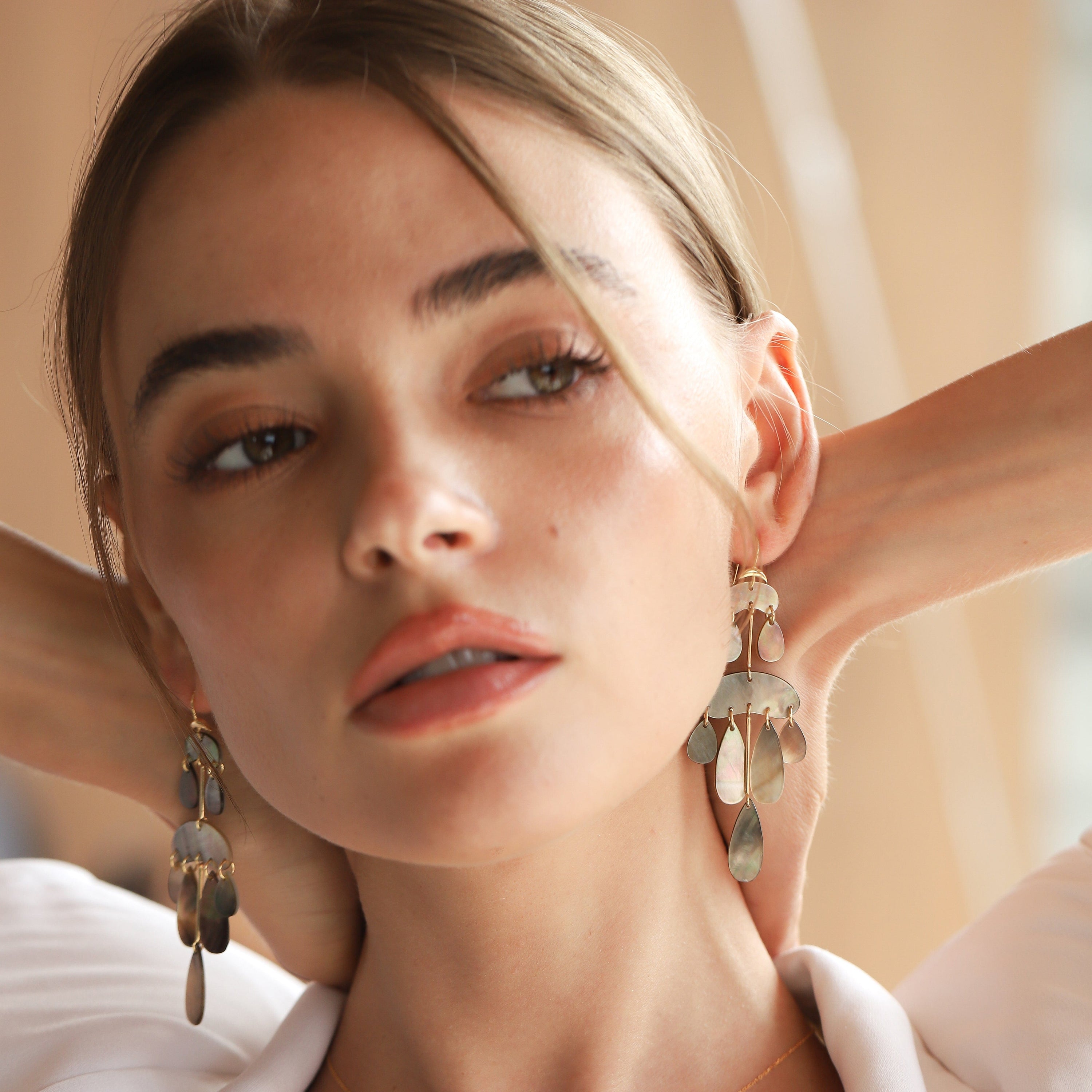 Mother-of-pearl chandelier earrings with gold hooks and layered teardrop drops, dark tones