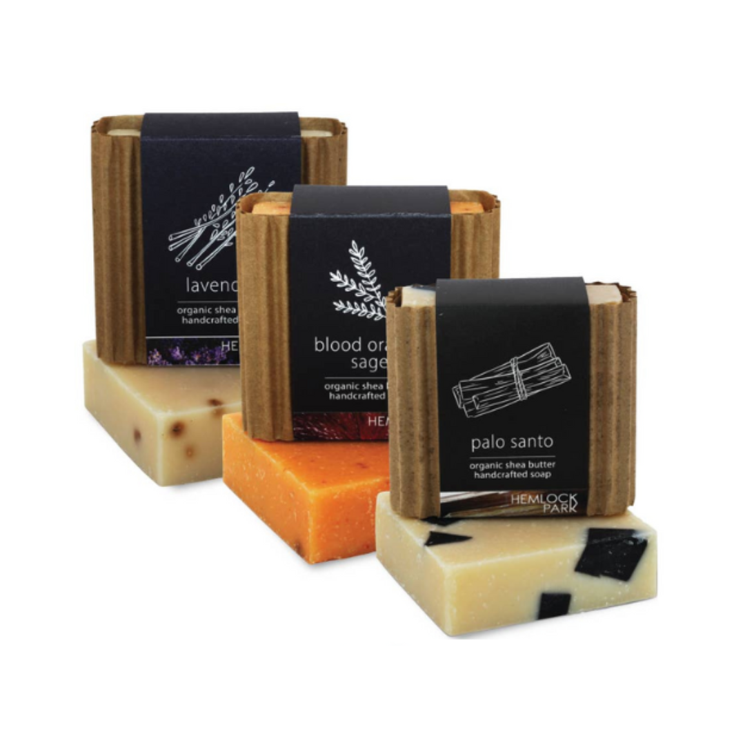 Assorted organic shea butter soap bars in multiple colors with dark label wraps