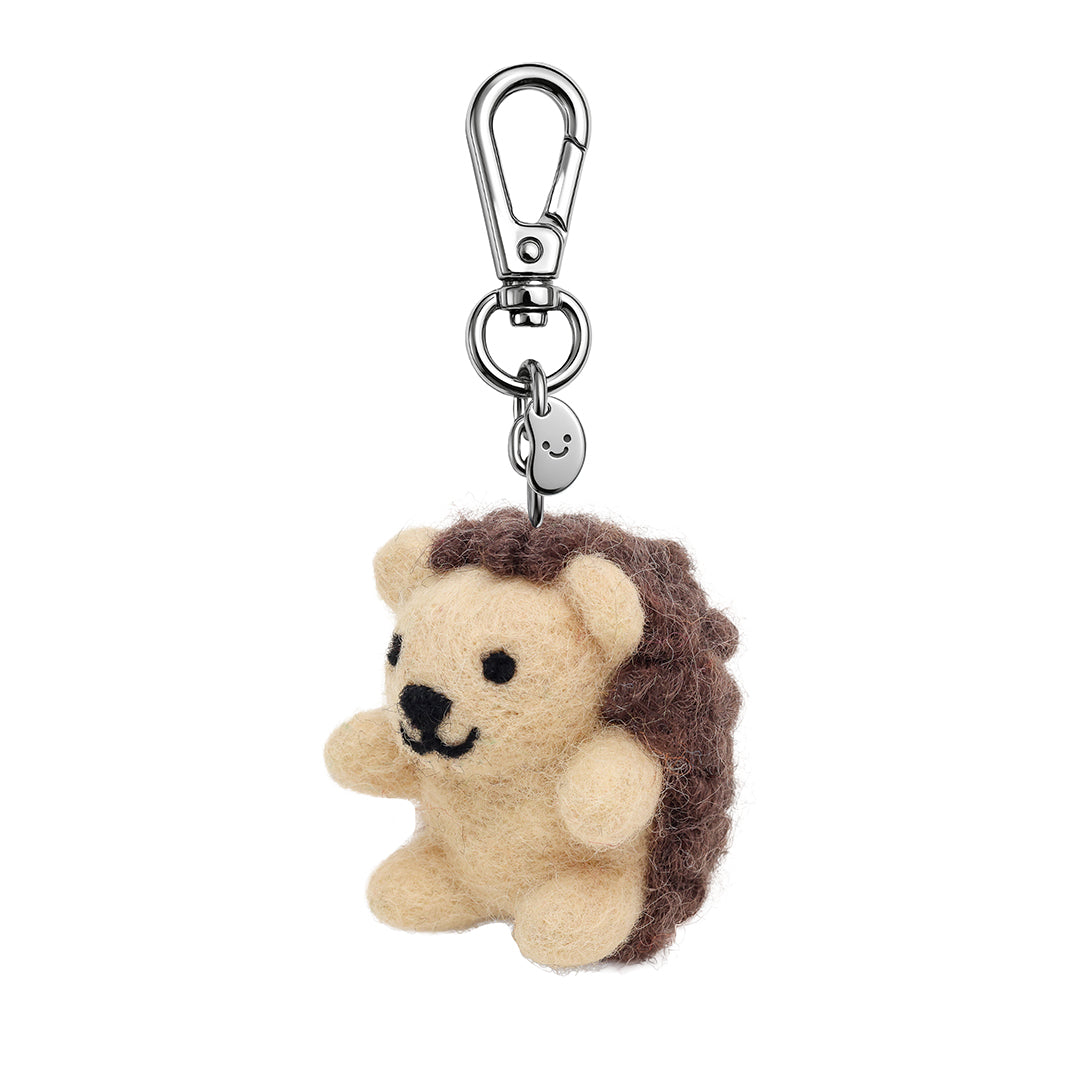 Felt animal keychain with beige head, dark curly hair, and metal clip