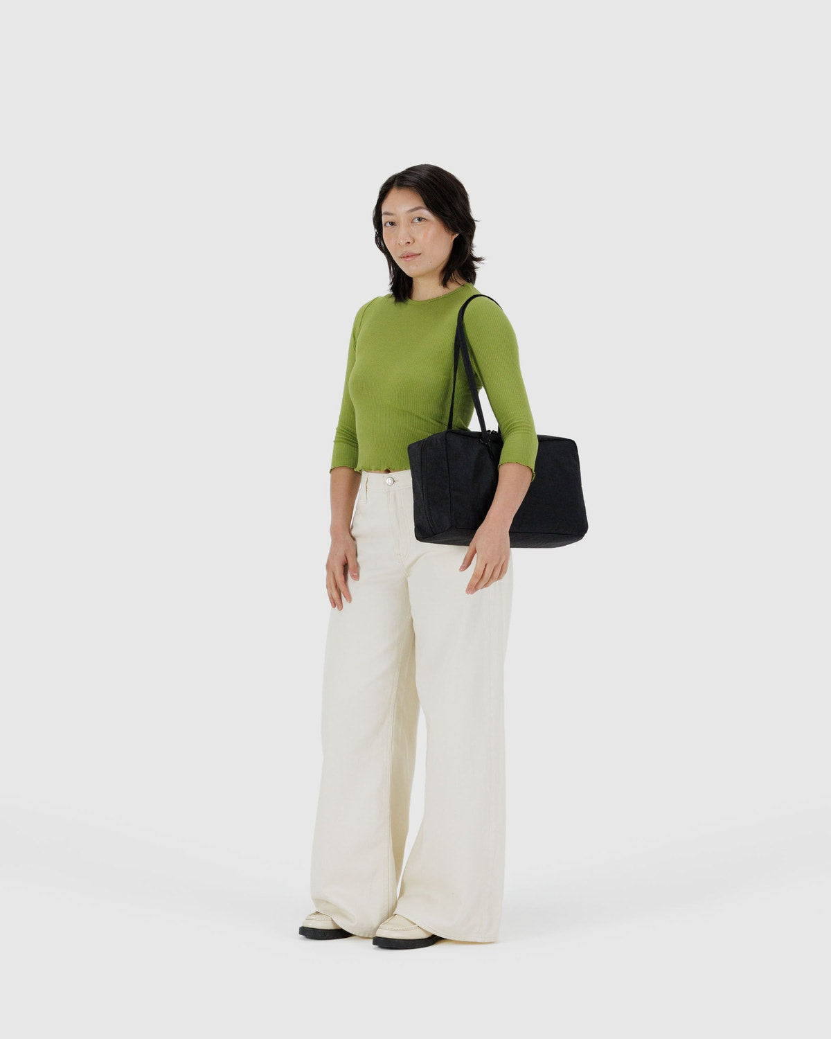 Black nylon bowler bag on model, top zip and short handles