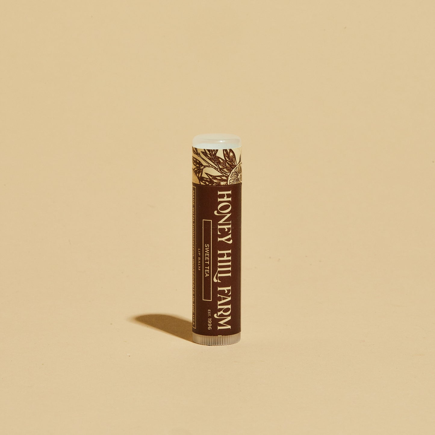 Lip balm tube with brown label and white cap