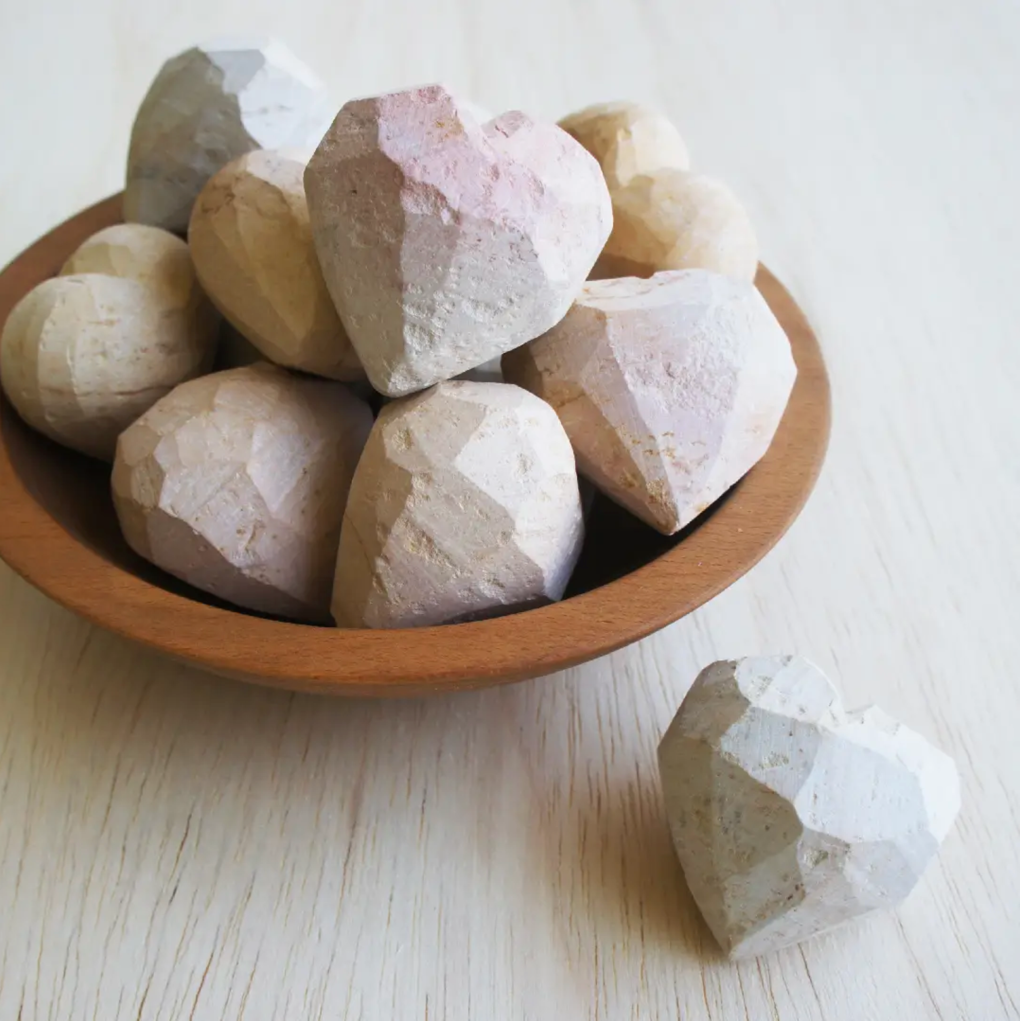 Soapstone heart stones in a wooden bowl, white with pink and tan speckles