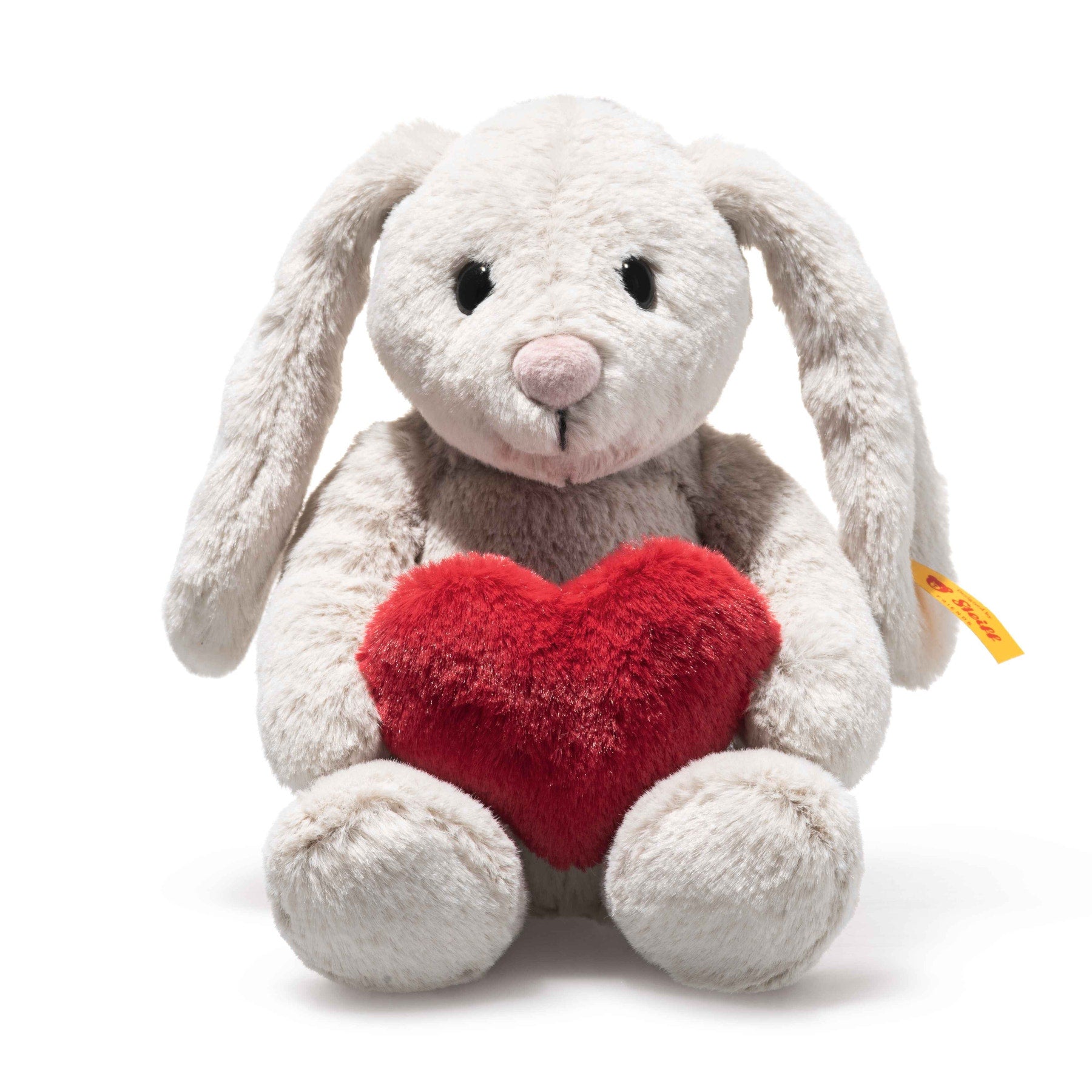 Stuffed plush rabbit with red heart on its chest, light gray fur