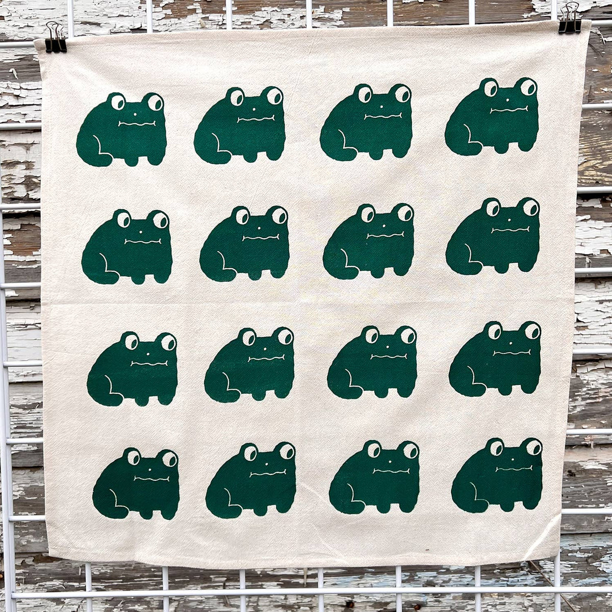 Frog tea towel, white cotton with repeating green cartoon frog faces
