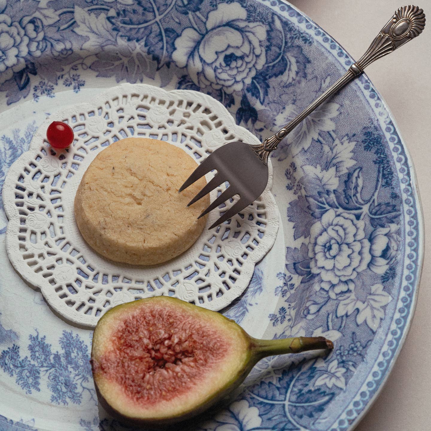 Vanilla Earl Grey shortbread cookie on a lace doily, with fig fruit and fork