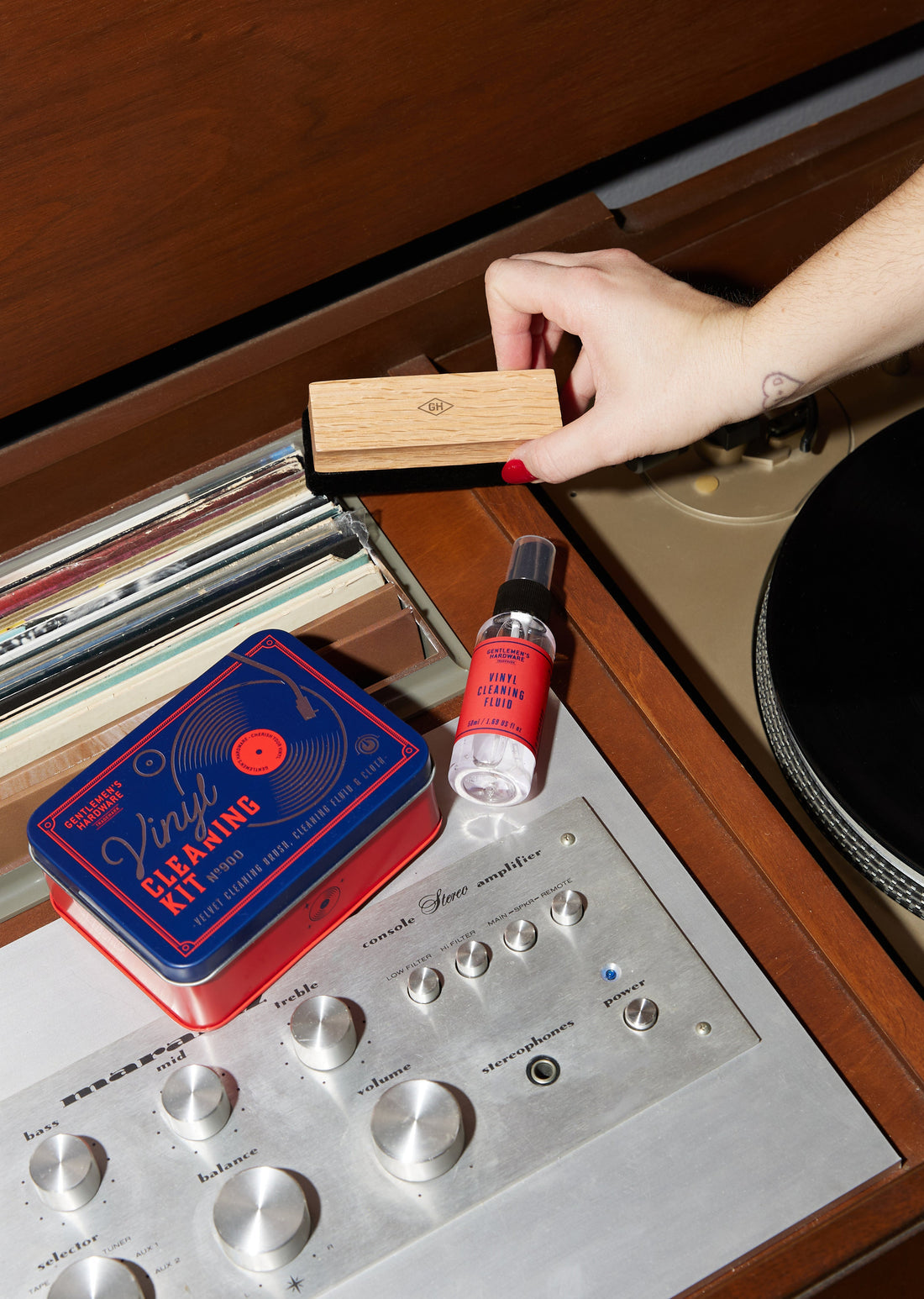 Vinyl cleaning kit components with velvet brush and fluid bottle on a turntable