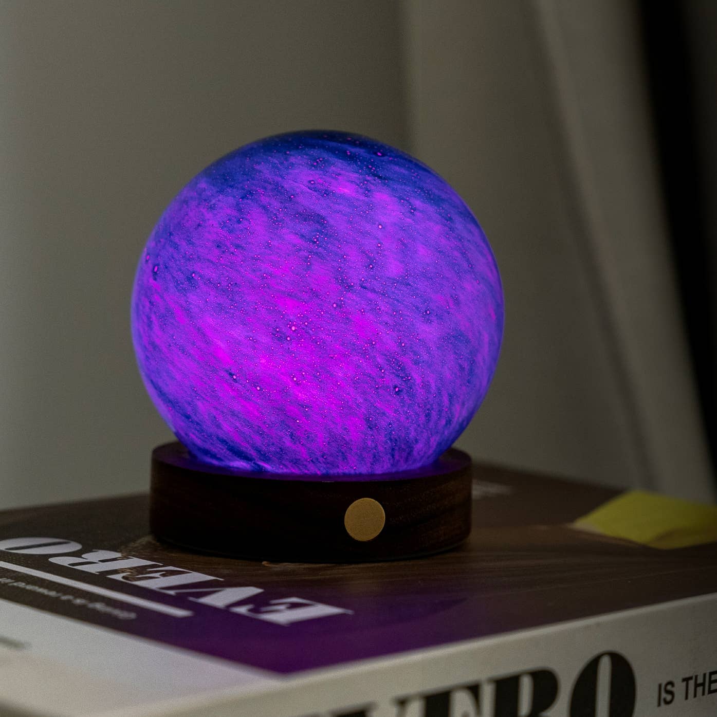 Mini purple galaxy glass light with swirling glow globe on dark round base