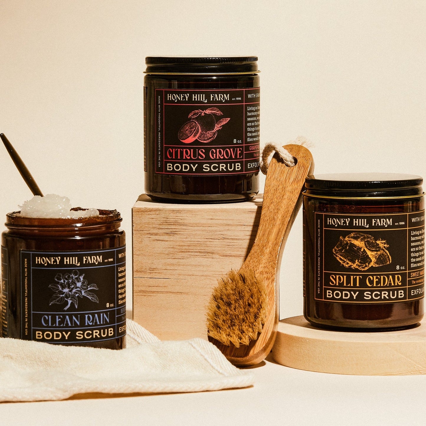 Body scrub jars with wooden exfoliating brush, Clean Rain and Split Cedar scents