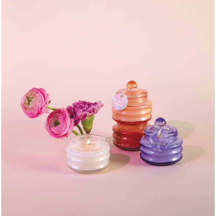Assorted glass jar candles with glowing wicks, plus small flower stems