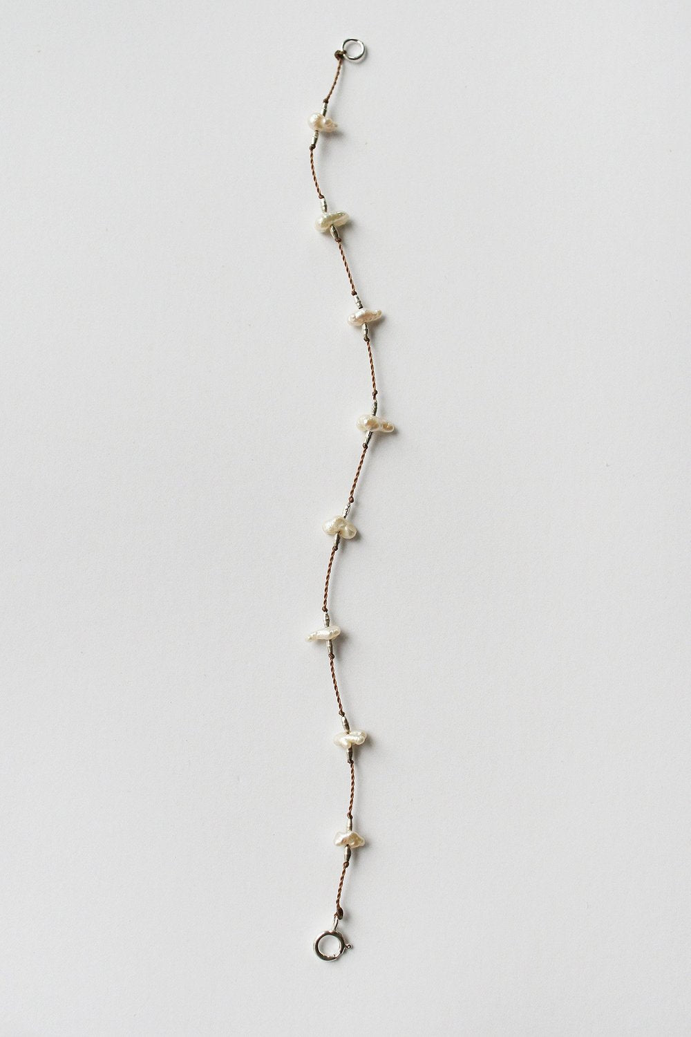 Keshi pearl bracelet with white keshi pearls on brown chain and small lobster clasp