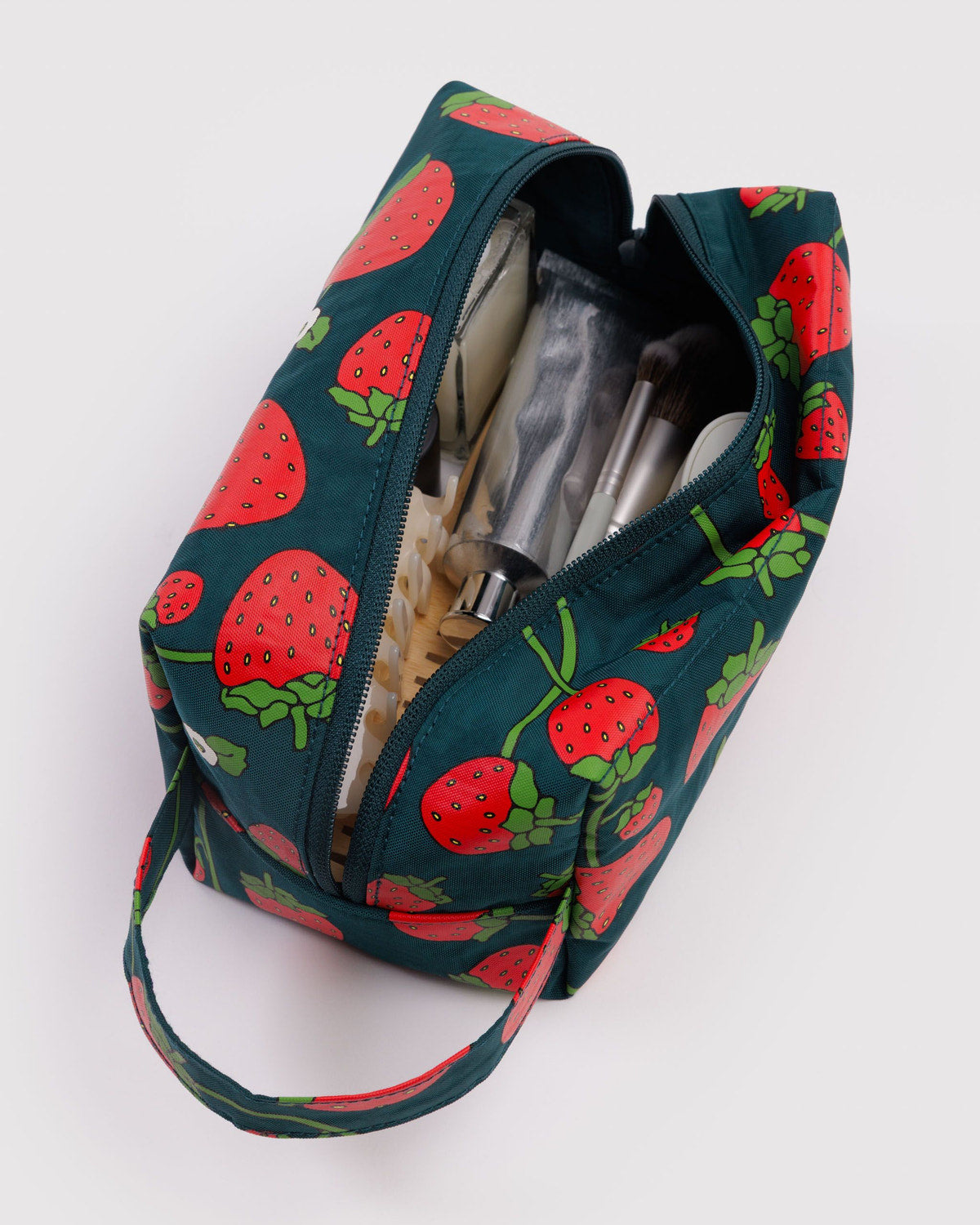 Dopp kit with strawberry print, teal exterior, zip-top opening and interior organizers