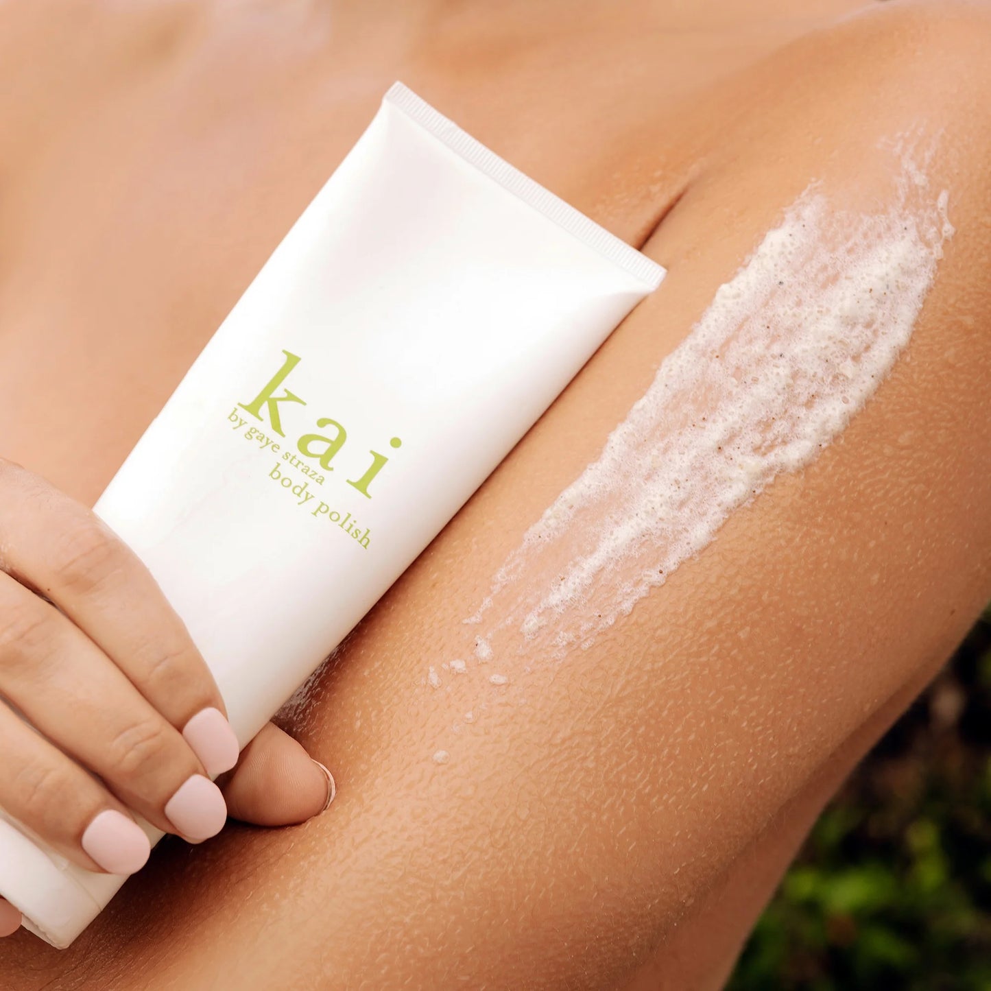 Kai body polish tube with exfoliating foam on arm