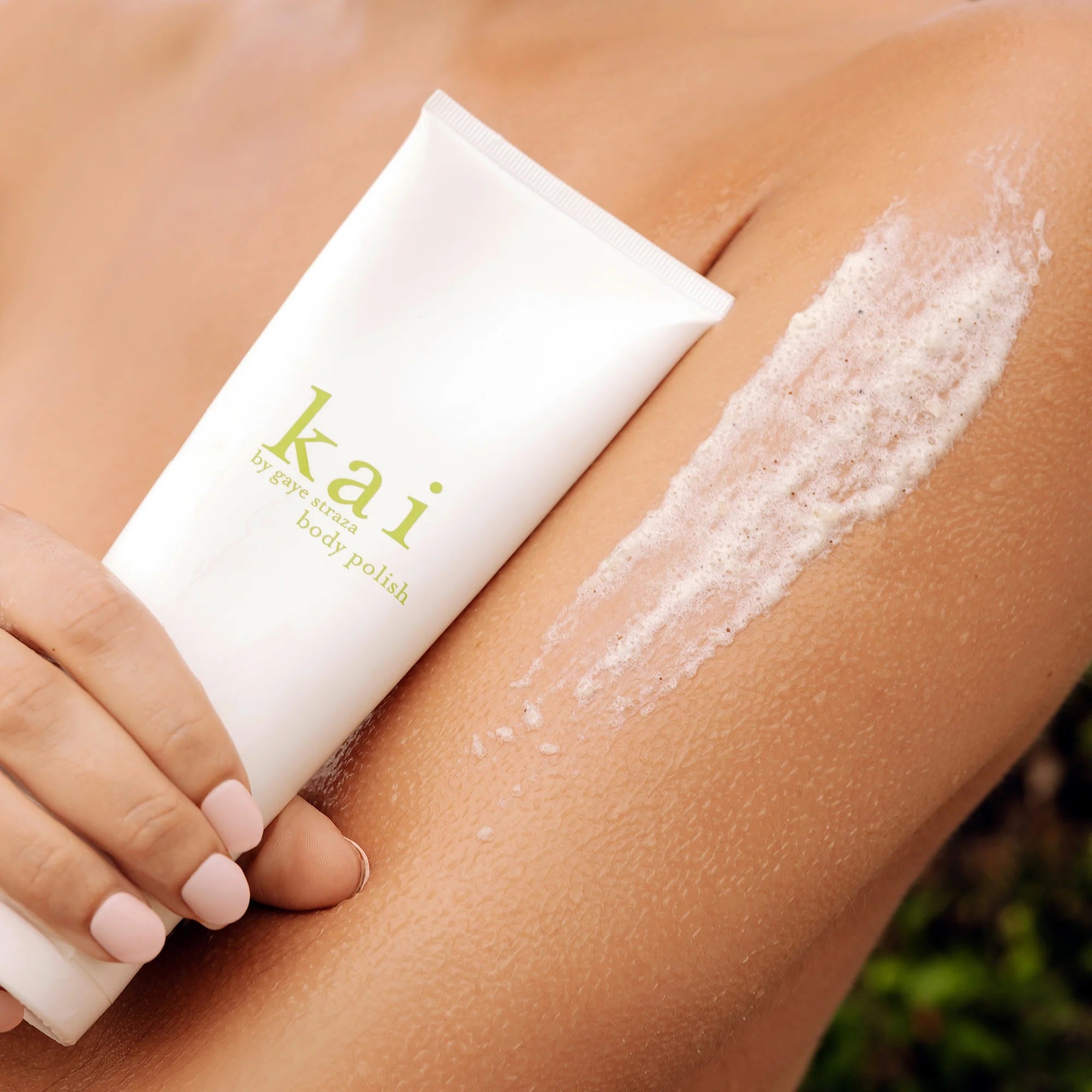 Kai body polish tube with exfoliating foam on arm