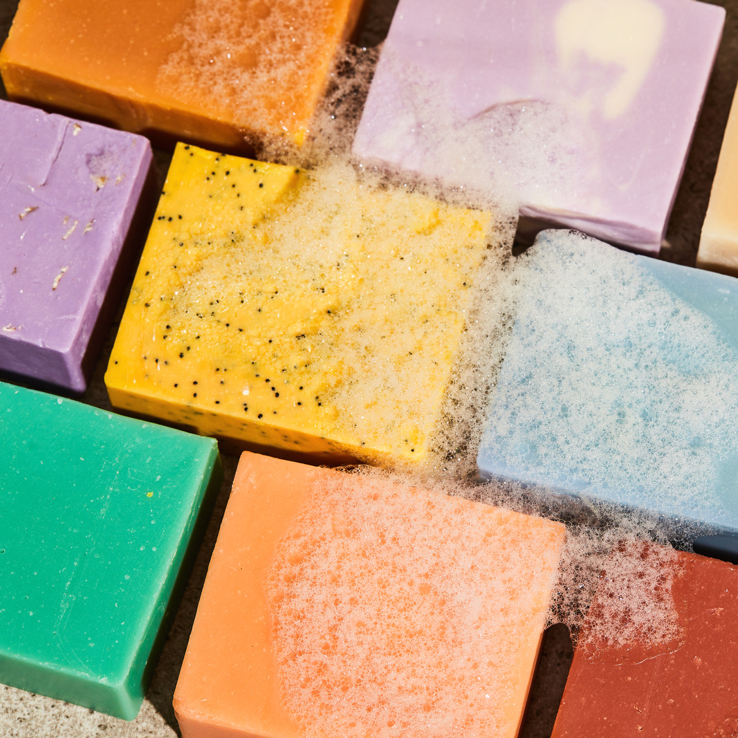 Assorted bar soaps with colorful bars and visible suds and texture on top.