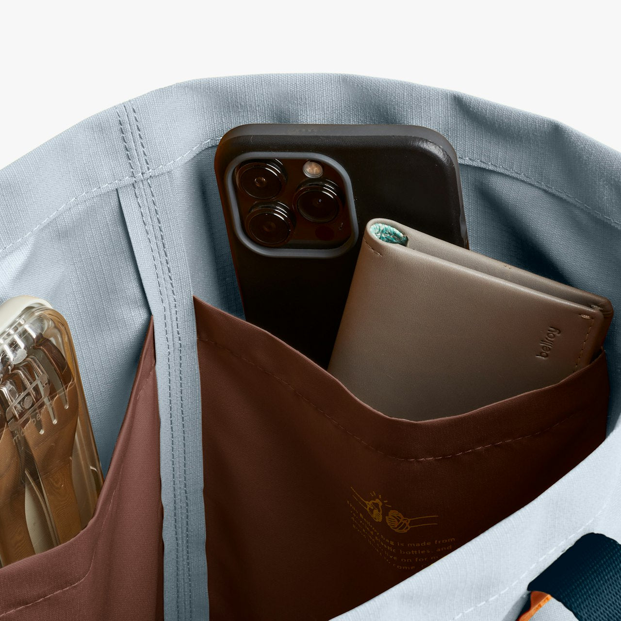 Tote bag interior with brown organizer pocket holding a smartphone and cards