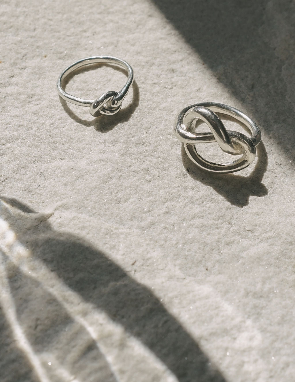 Silver ring from side view, circular band with twisted heart-knot centerpiece