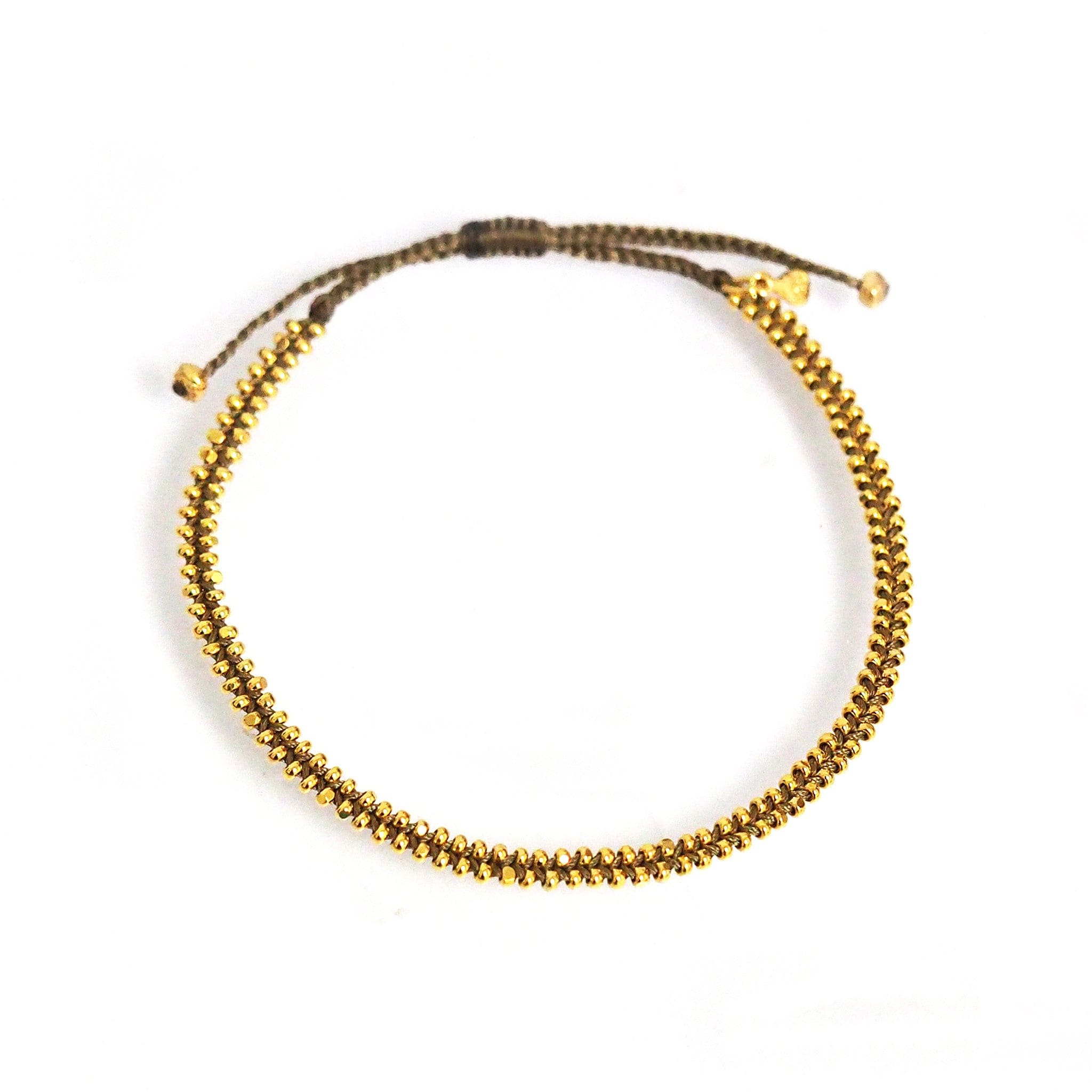 Beaded bracelet with gold bead accents on dark cord and small gold end caps