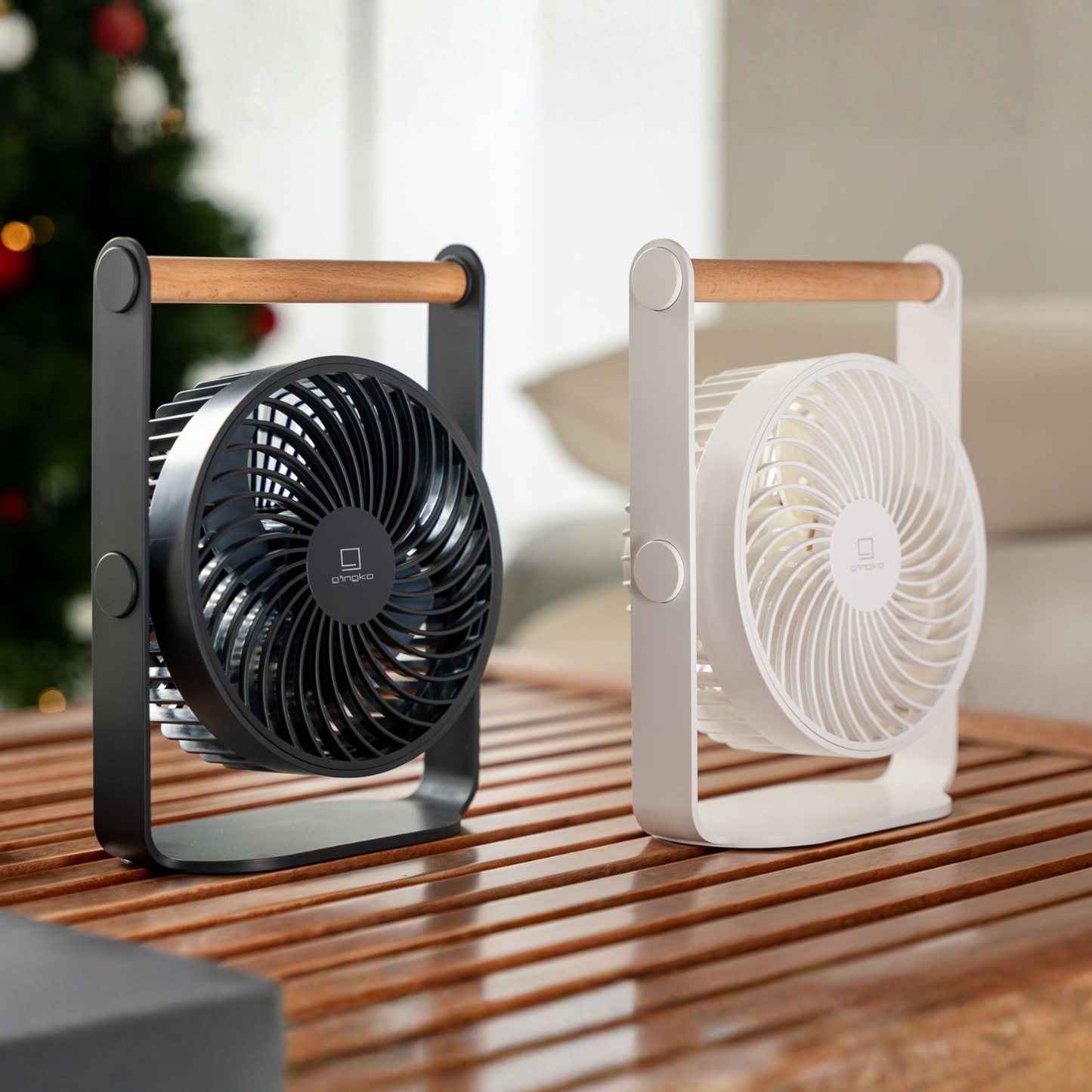Portable fan with wooden handle, black front grille; white fan beside it