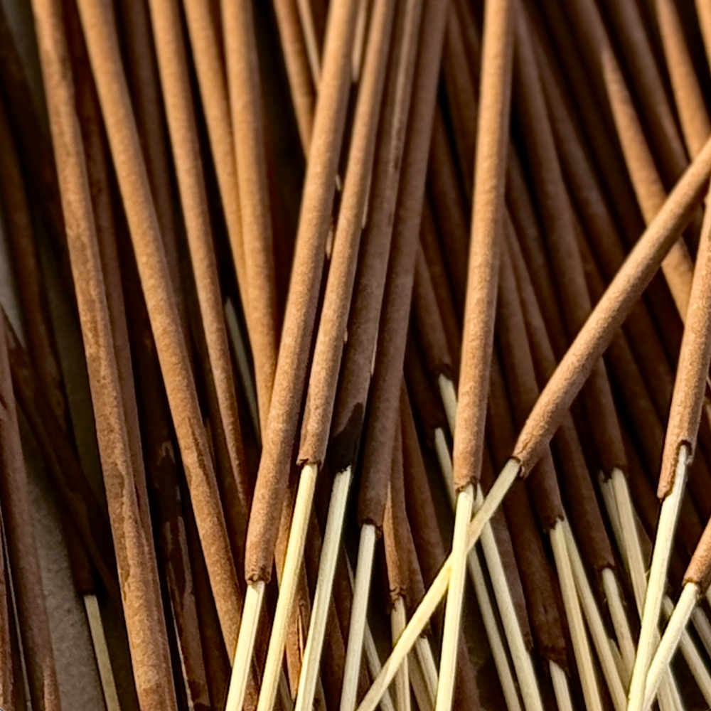 Hand-rolled incense sticks bundle, light and dark ends visible