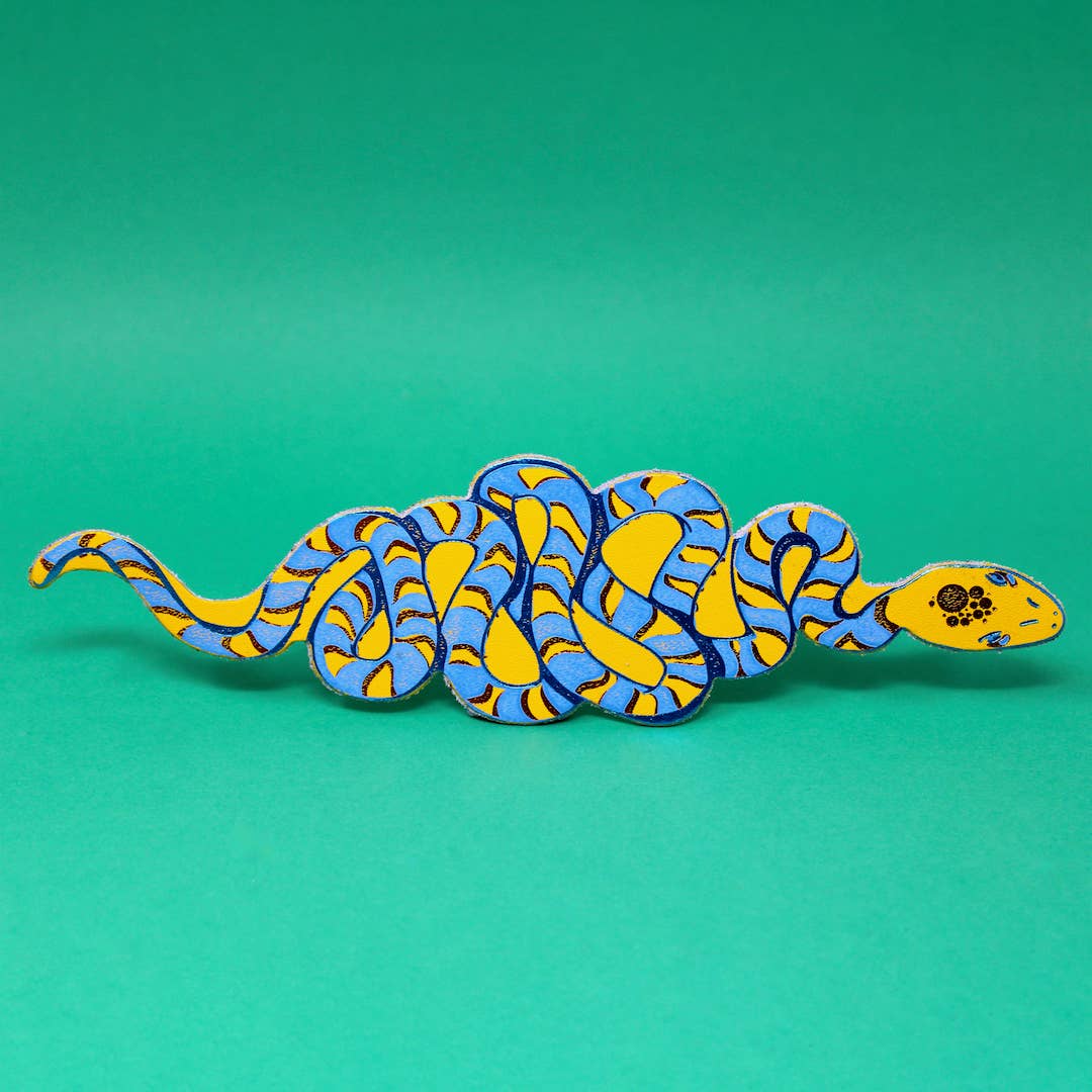 Yellow snake-shaped bookmark with blue and white swirl pattern, curled body and tail
