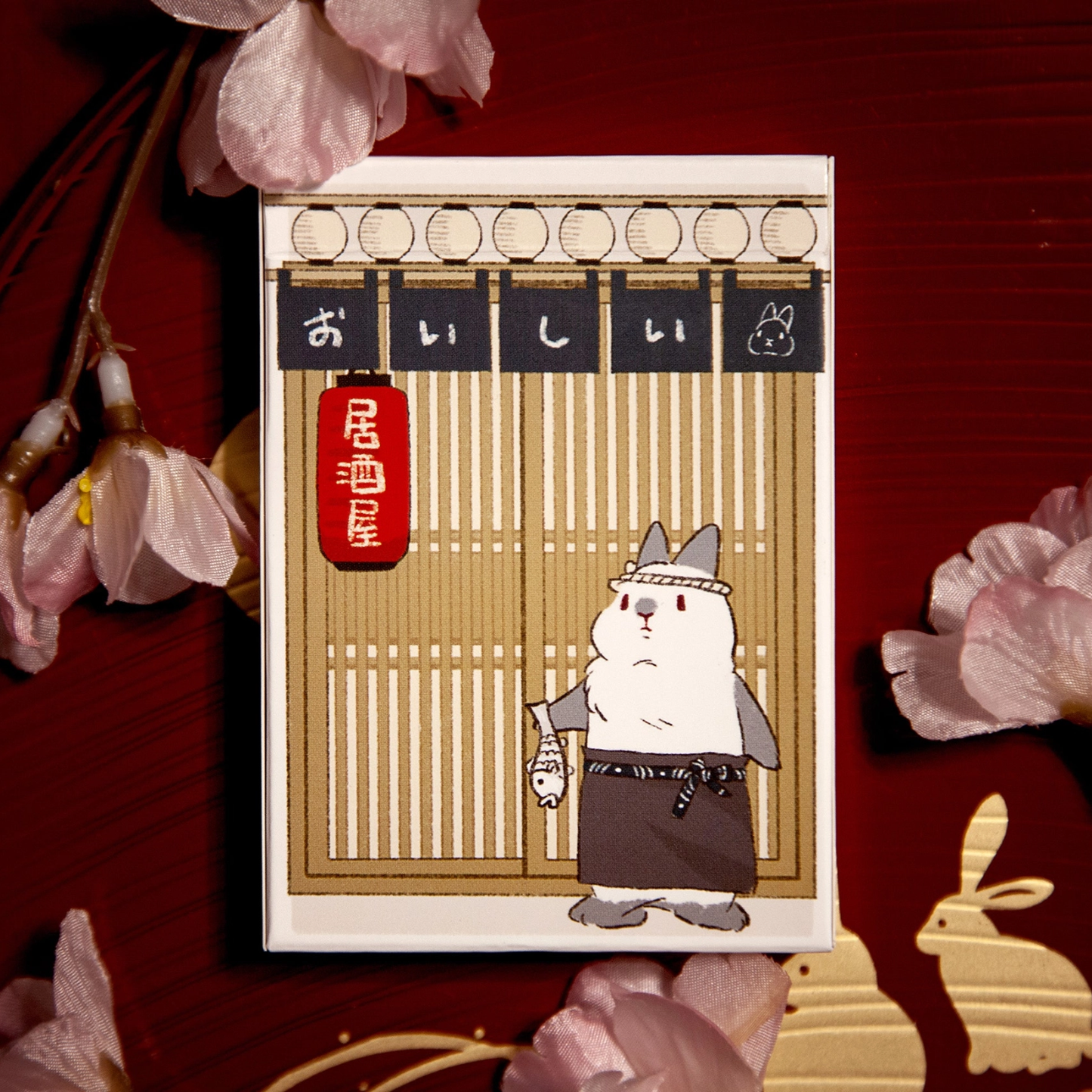 Deck of playing cards with cat illustration and gold striped border on front cover