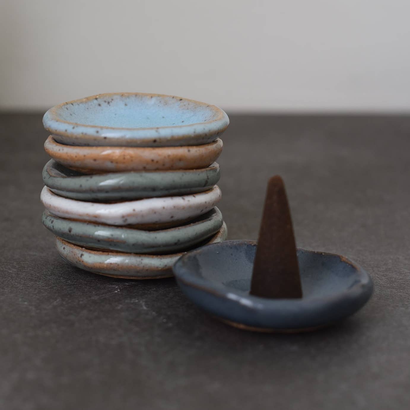 Stacked ceramic incense cone holder dish, blue-gray tones with dark cone
