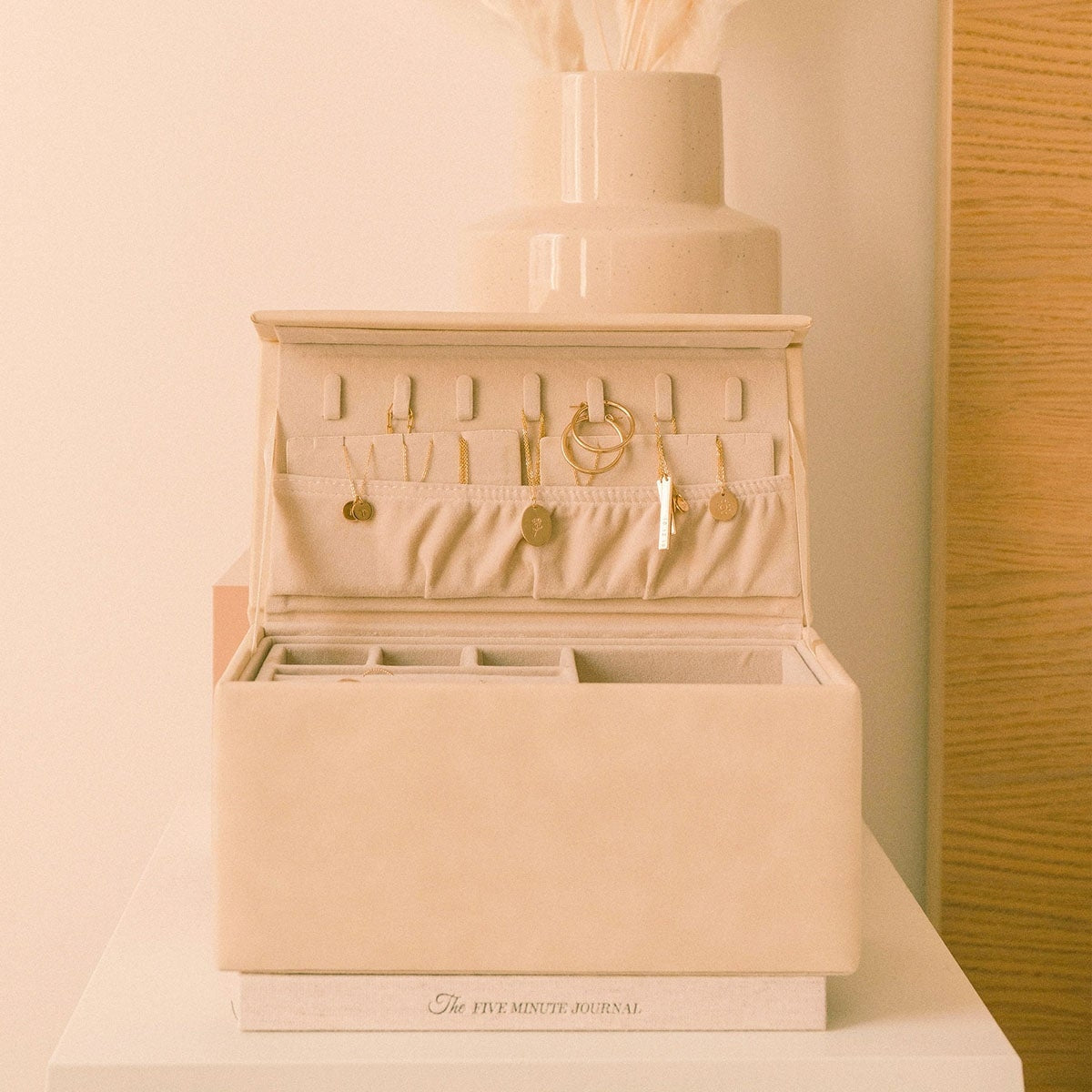 Open cream vegan leather jewelry box with earring and ring sections on display.