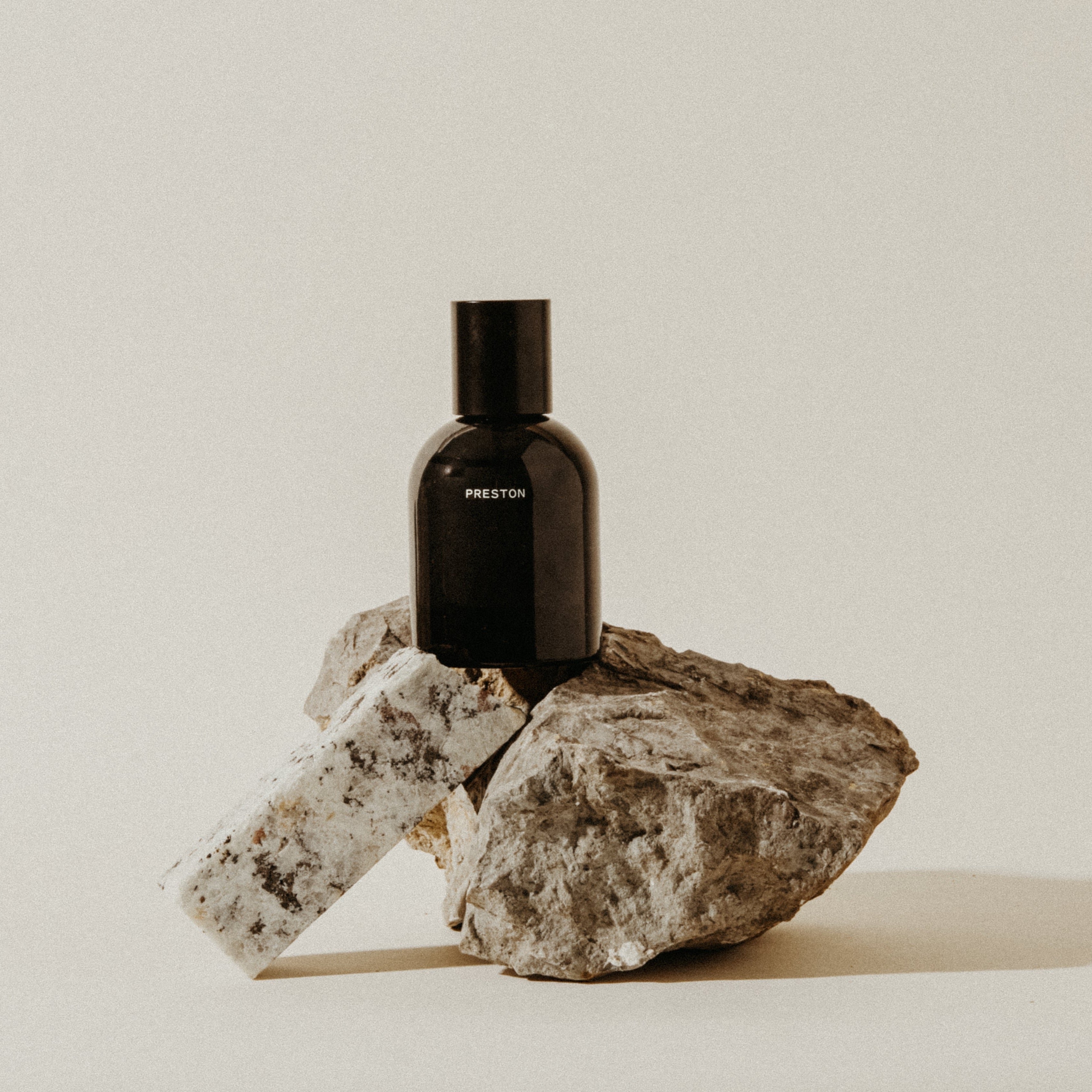 Cologne 1.7 oz bottle with Leather label, black glass on stone