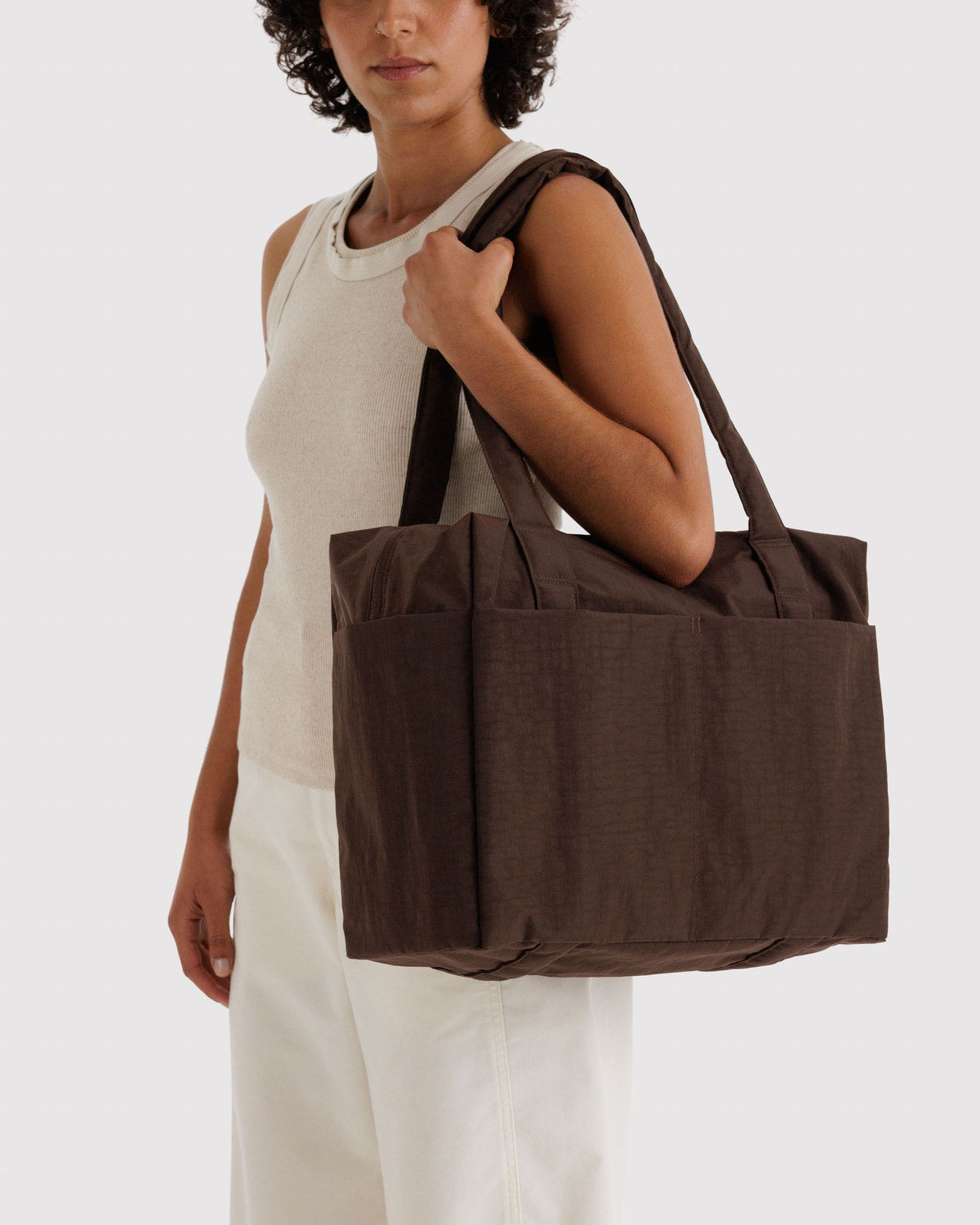 Brown carry-on tote bag worn on the shoulder with top handles
