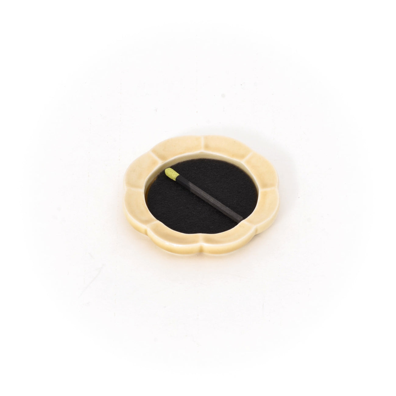 Cream-yellow ceramic incense tray with black incense pad and two incense sticks