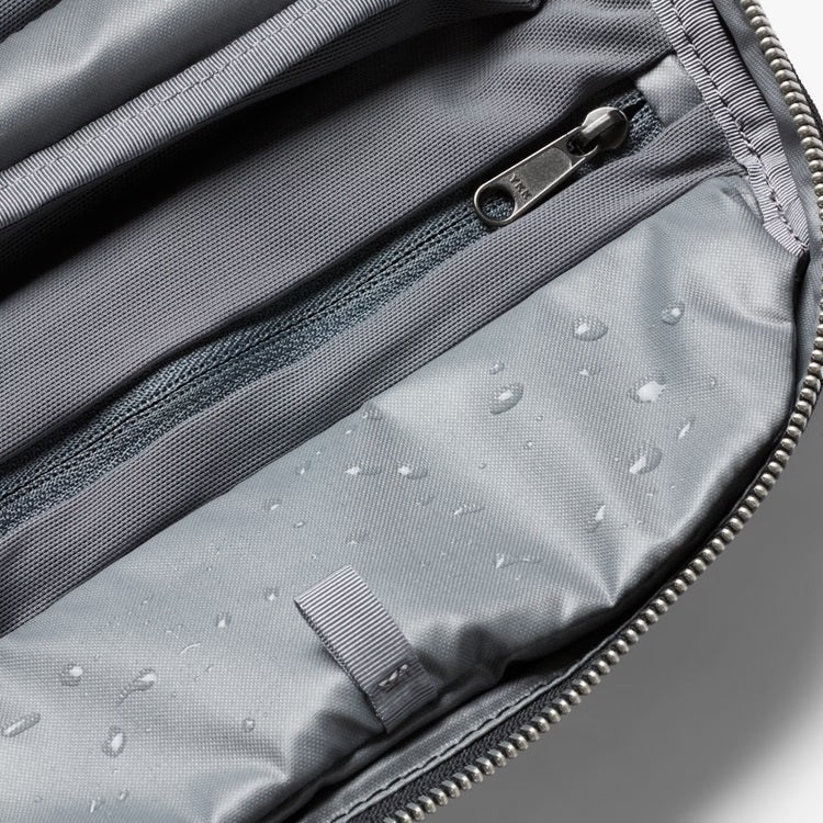 Toiletry kit interior with gray water-resistant lining, zip pocket, and strap