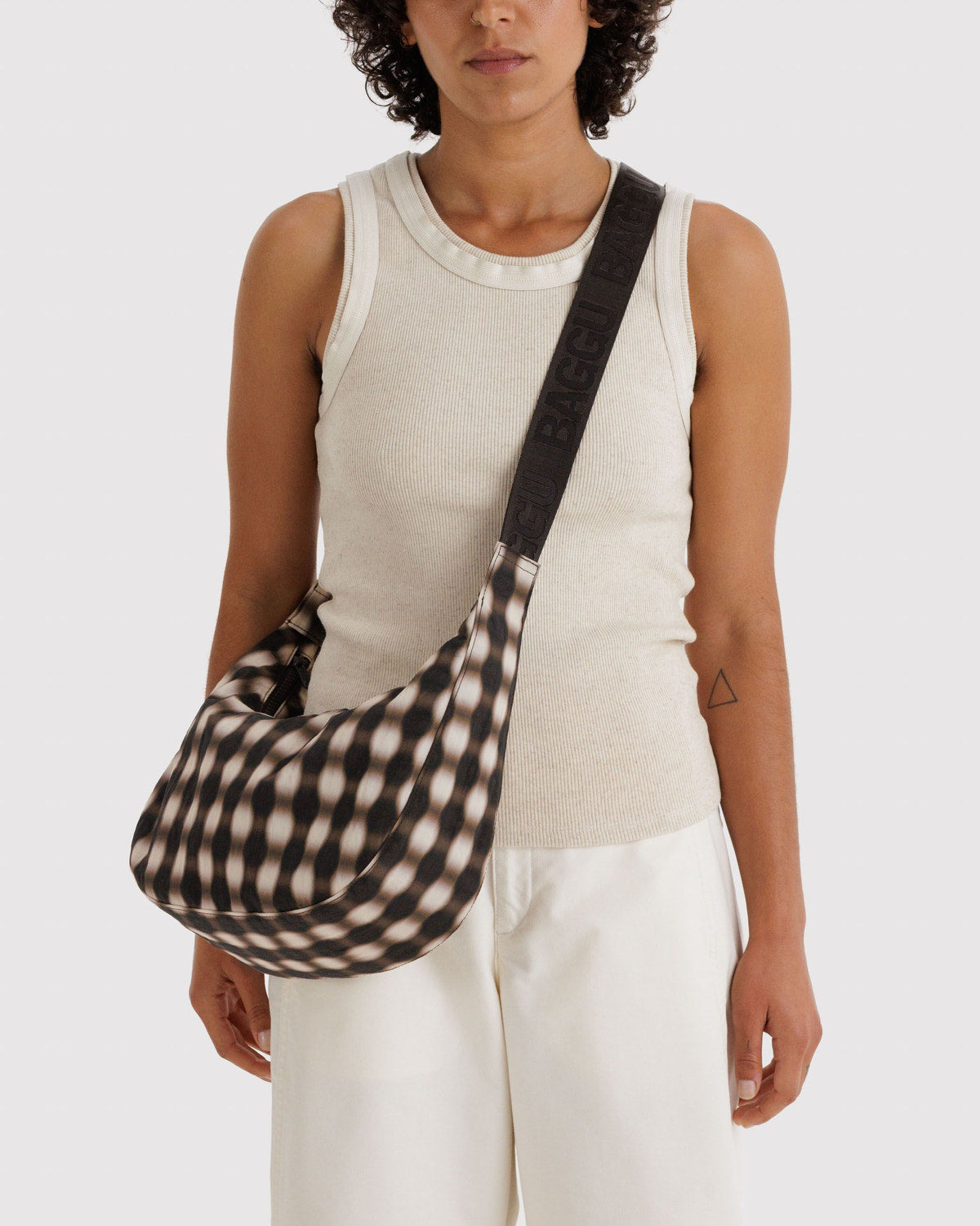 Medium crescent nylon bag, black-and-cream gingham print, crossbody on shoulder