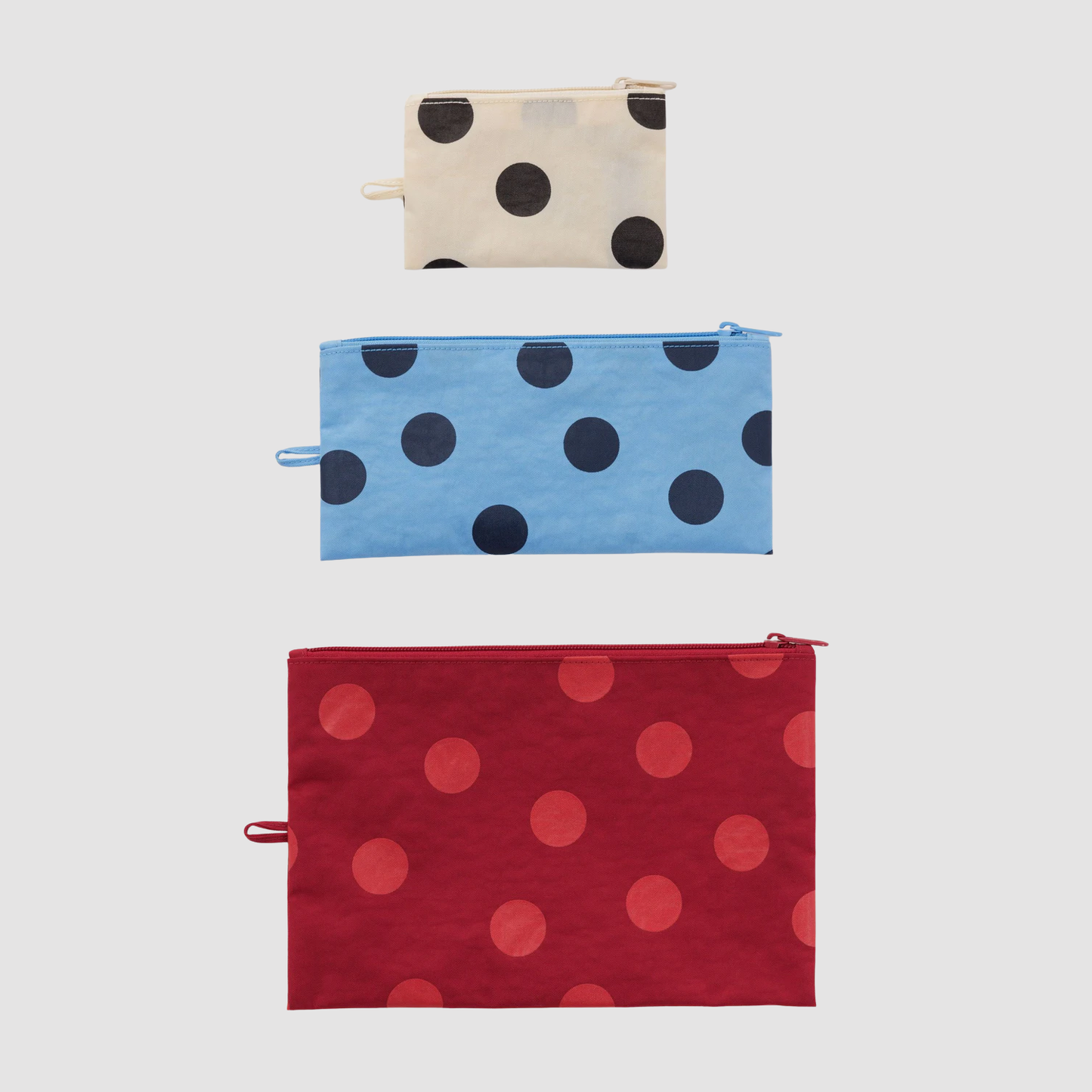 Set of three flat zip pouches with polka dots: cream, blue, and red
